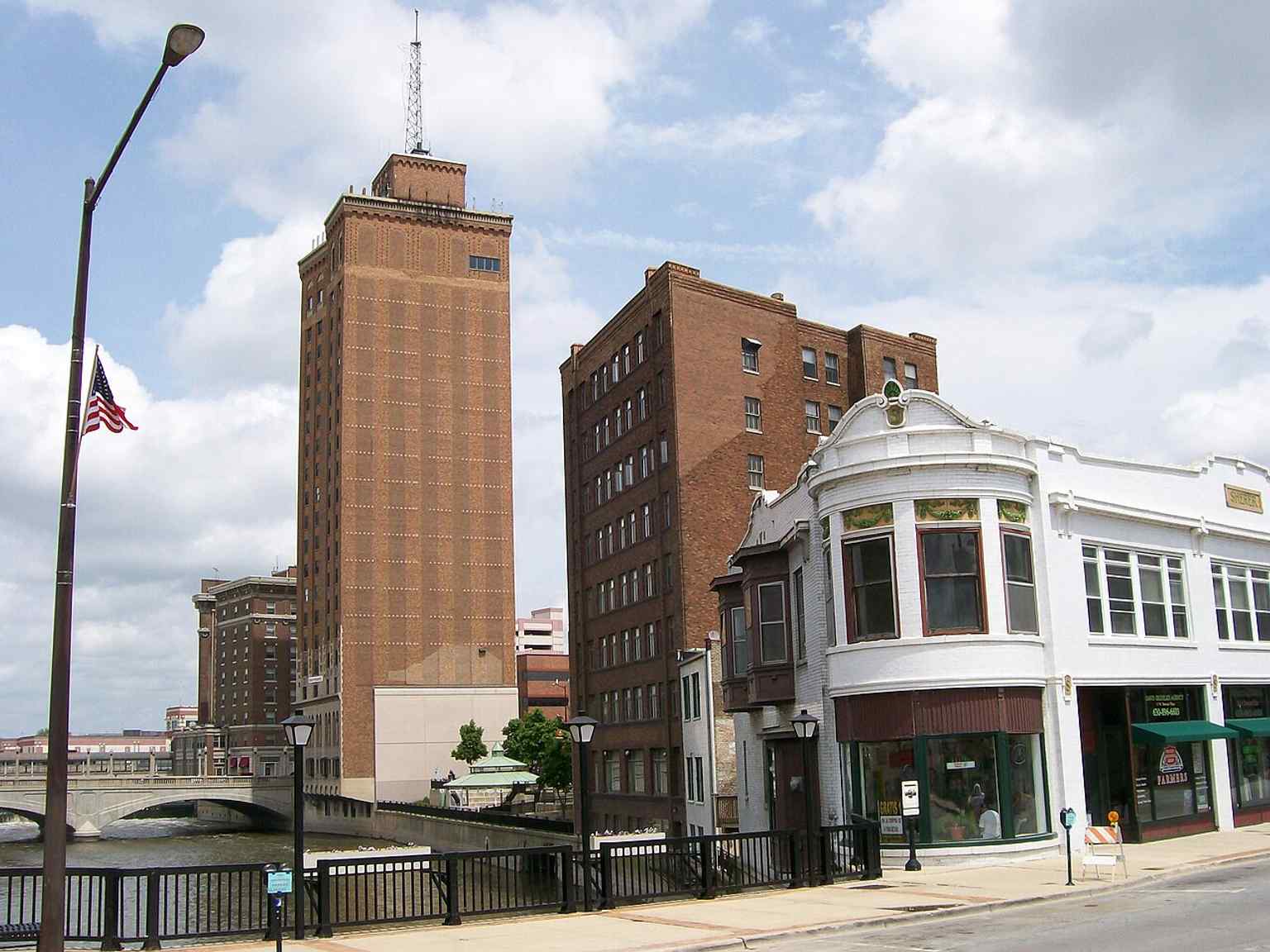 A broad view across the Fox River shows several Stolp Island buildings together, reflecting how the island linked Aurora’s east and west sides.