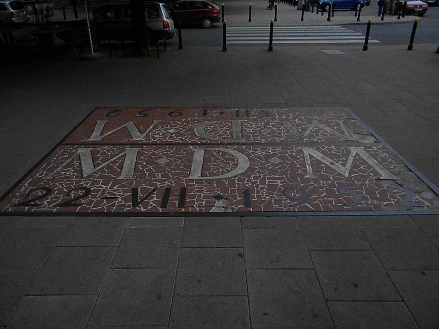 A street mosaic on the square, part of the decorative ground-level artwork that gives the district its character.