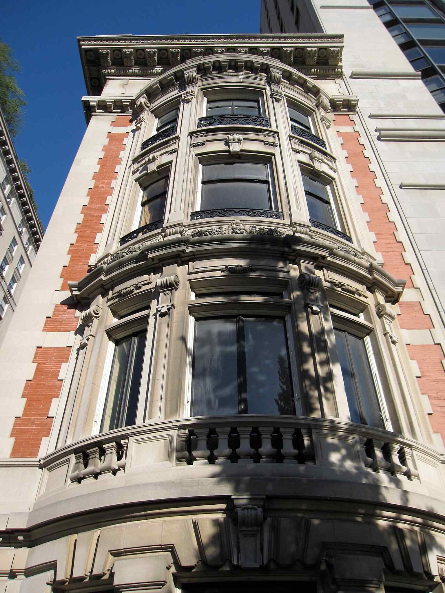 The Fifth Avenue facade showcases the house's Beaux-Arts style, featuring three distinctive curved bays, a design choice described as resembling the Baroque style.
