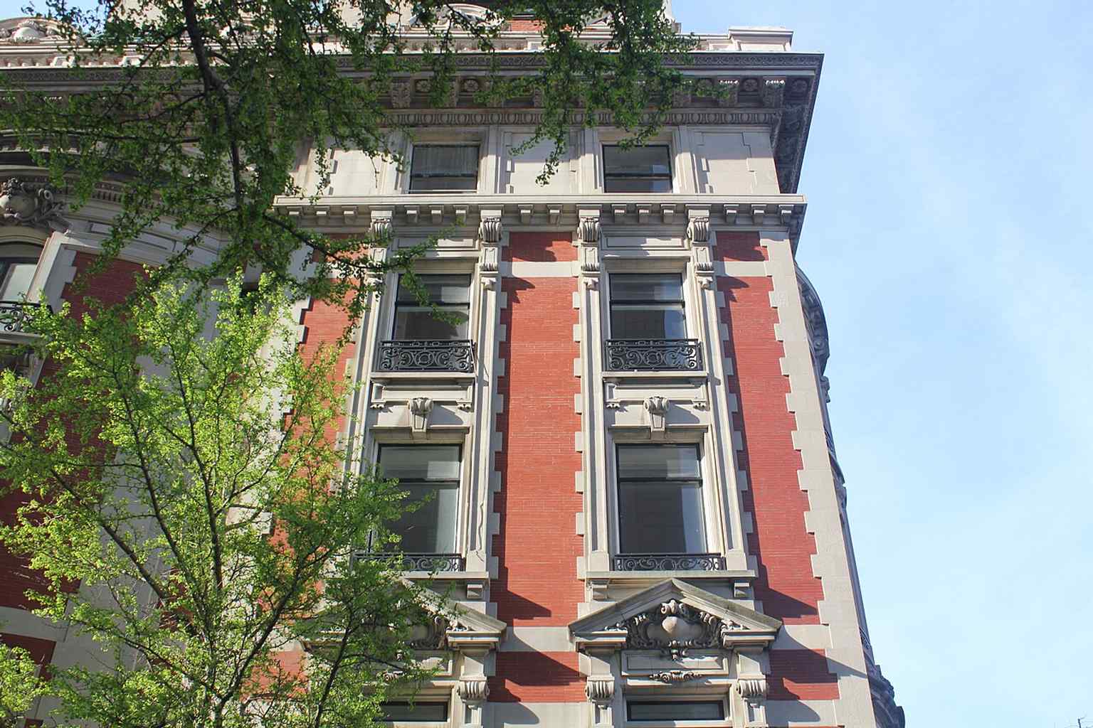 The red brick facade of the upper floors, punctuated by limestone quoins and wrought-iron window guards, was restored to its original Gilded Age coloration in the 1980s.
