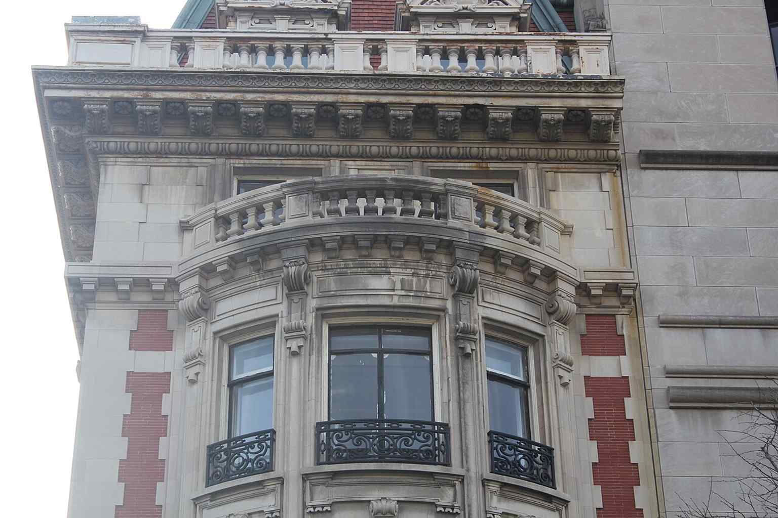 A closer look at one of the curved bays on Fifth Avenue emphasizes the Baroque-influenced curvature and the intricate limestone balustrades.