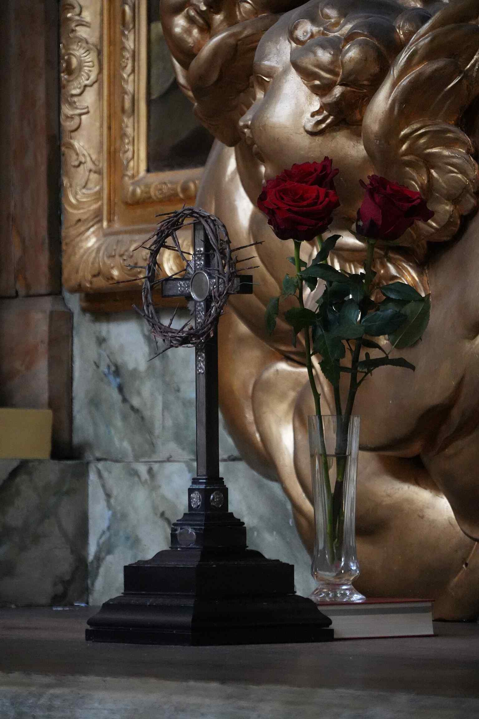 A close altar detail with crucifix and roses, evoking the liturgical atmosphere of Hedvig Eleonora Church during Holy Week.