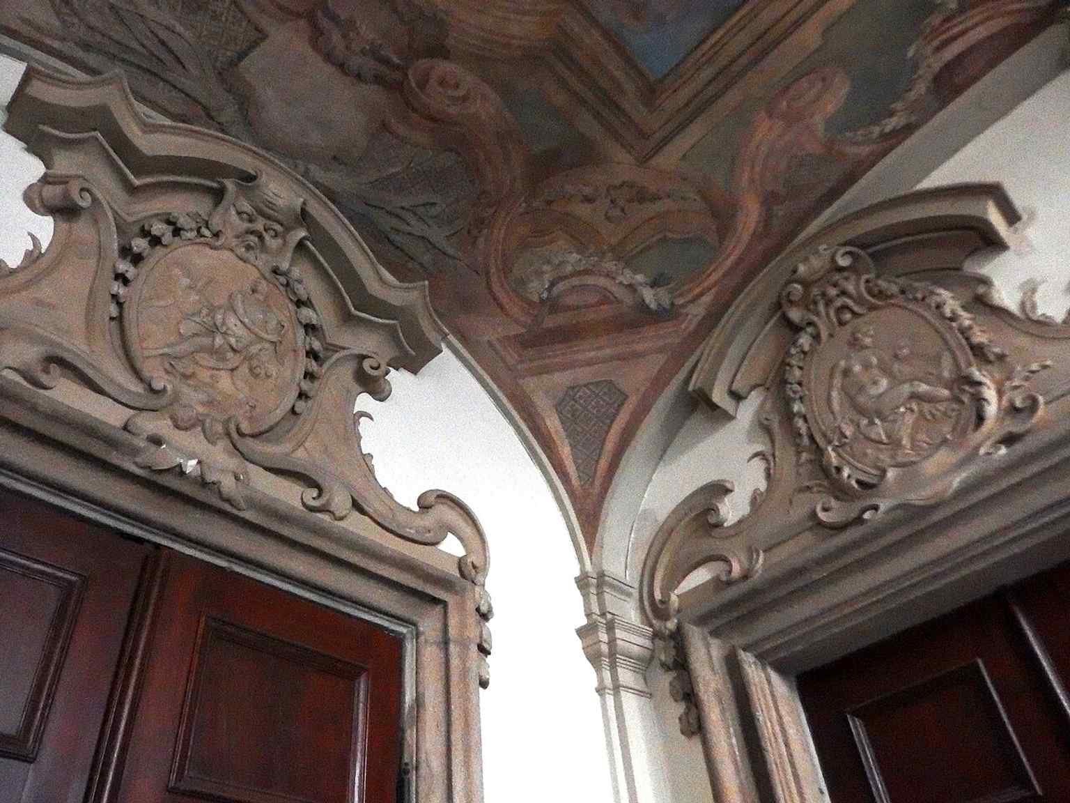Ein Detail einer Supraporte mit einem Maskaron zeigt die filigrane Bildhauerarbeit aus der Werkstatt von Maty!š Bernard Braun, einem Meister der Prager Barockkunst.