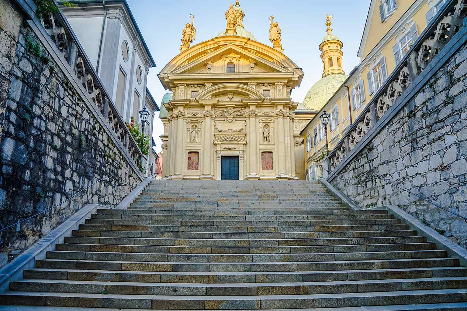 The staircase in warm evening light emphasizes the monumental entrance, leading up to one of Austria’s most important Mannerist church complexes.