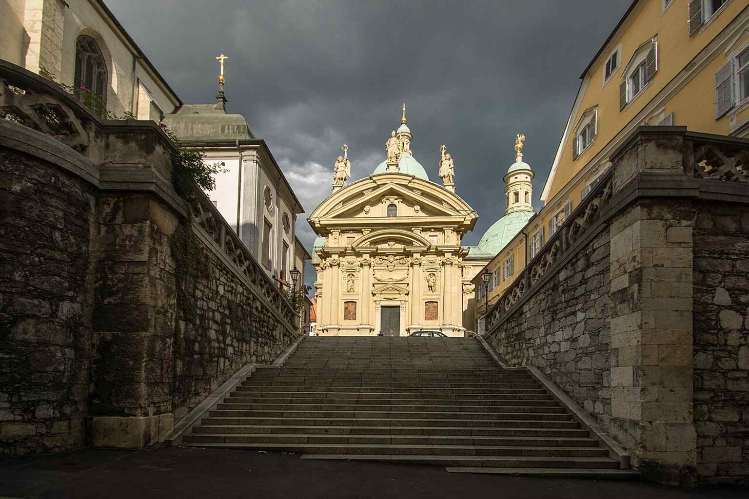 The entrance façade and stairway capture the building’s representative front, where Catholic and dynastic symbolism meets in stone.