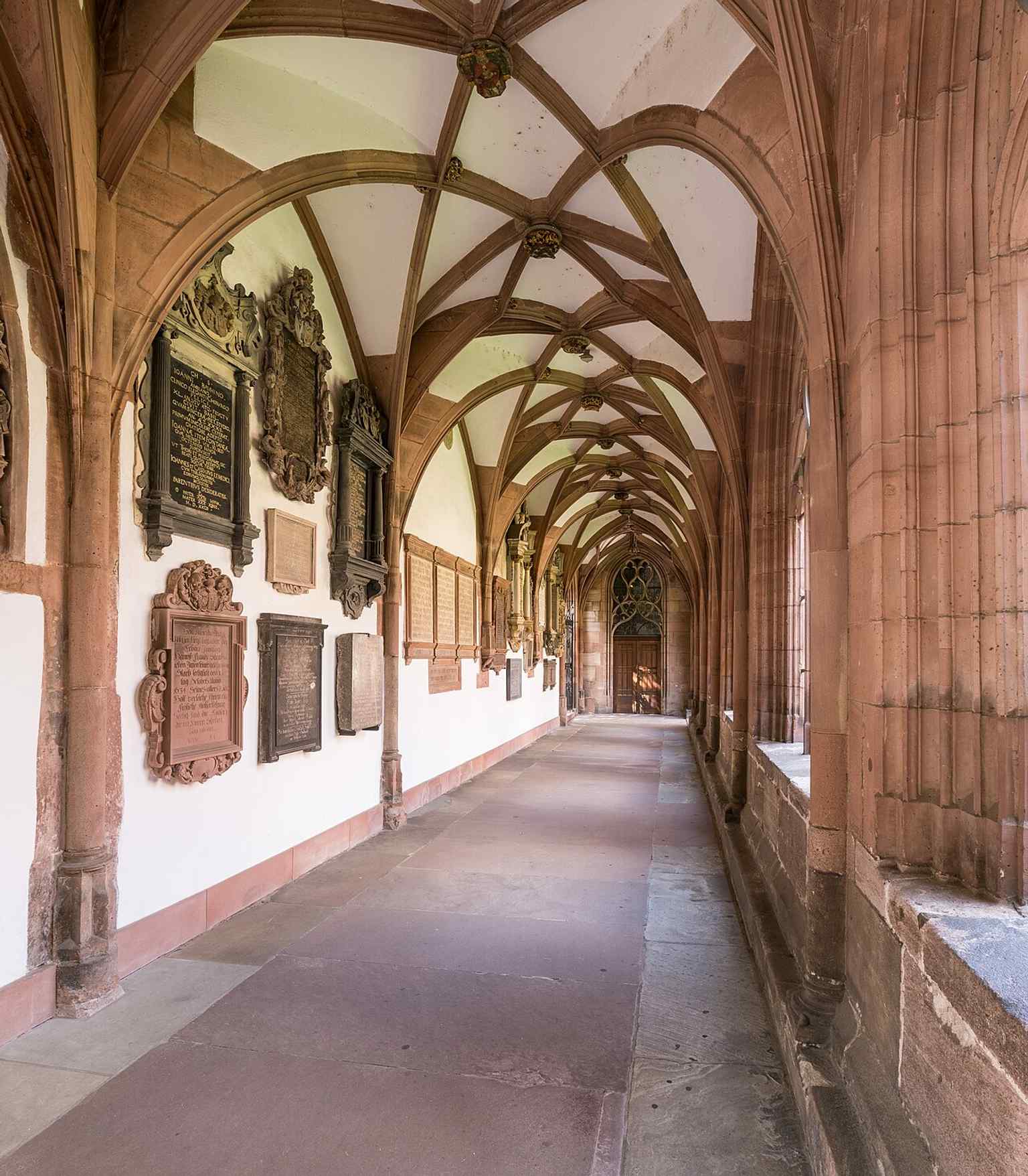 Another view inside the great cloister, where tomb slabs and memorials line the walls around the medieval monastery walk.