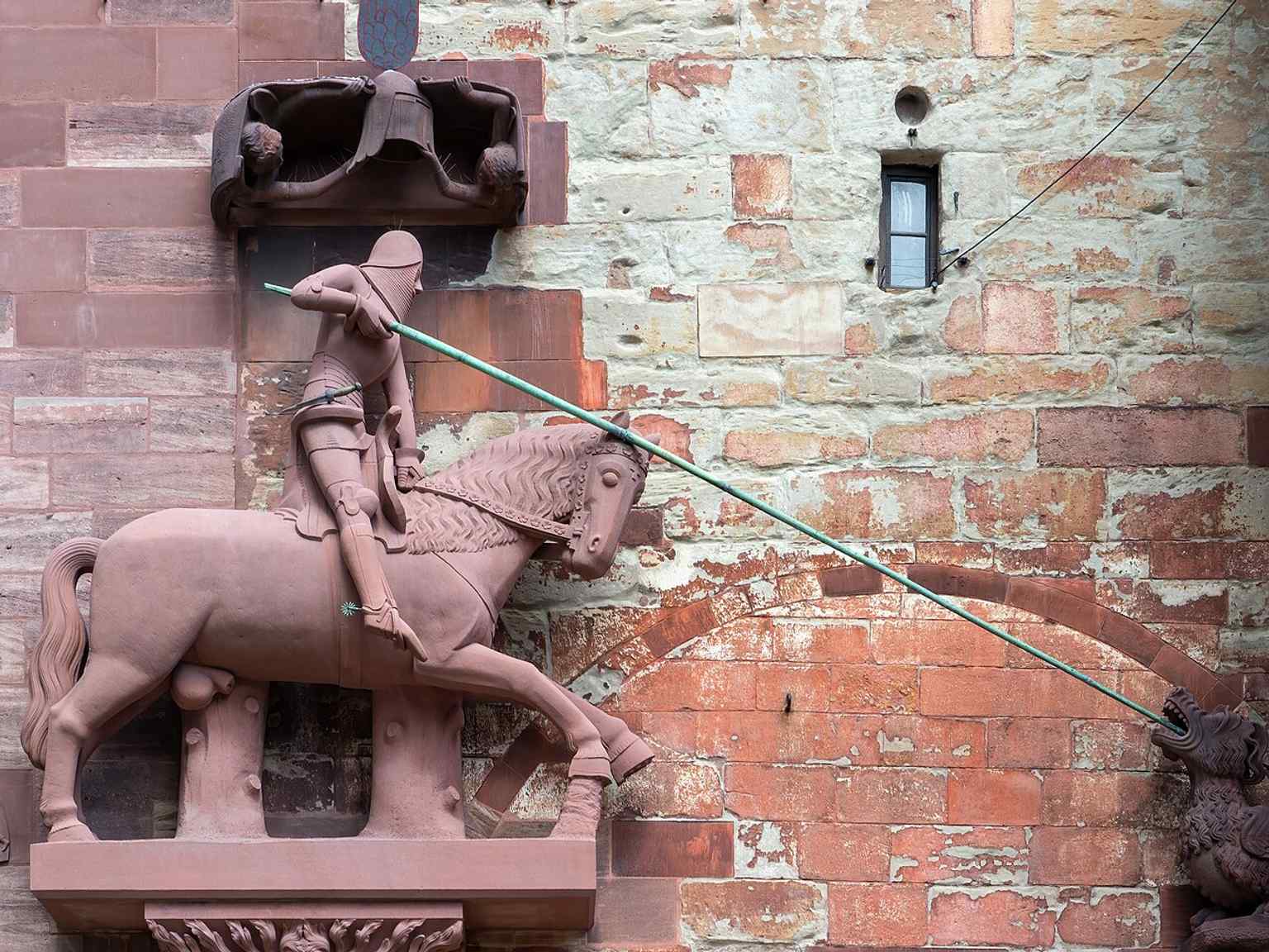 Saint George on the facade — the northern tower saint, whose slaying of the dragon is carved in monumental scale.