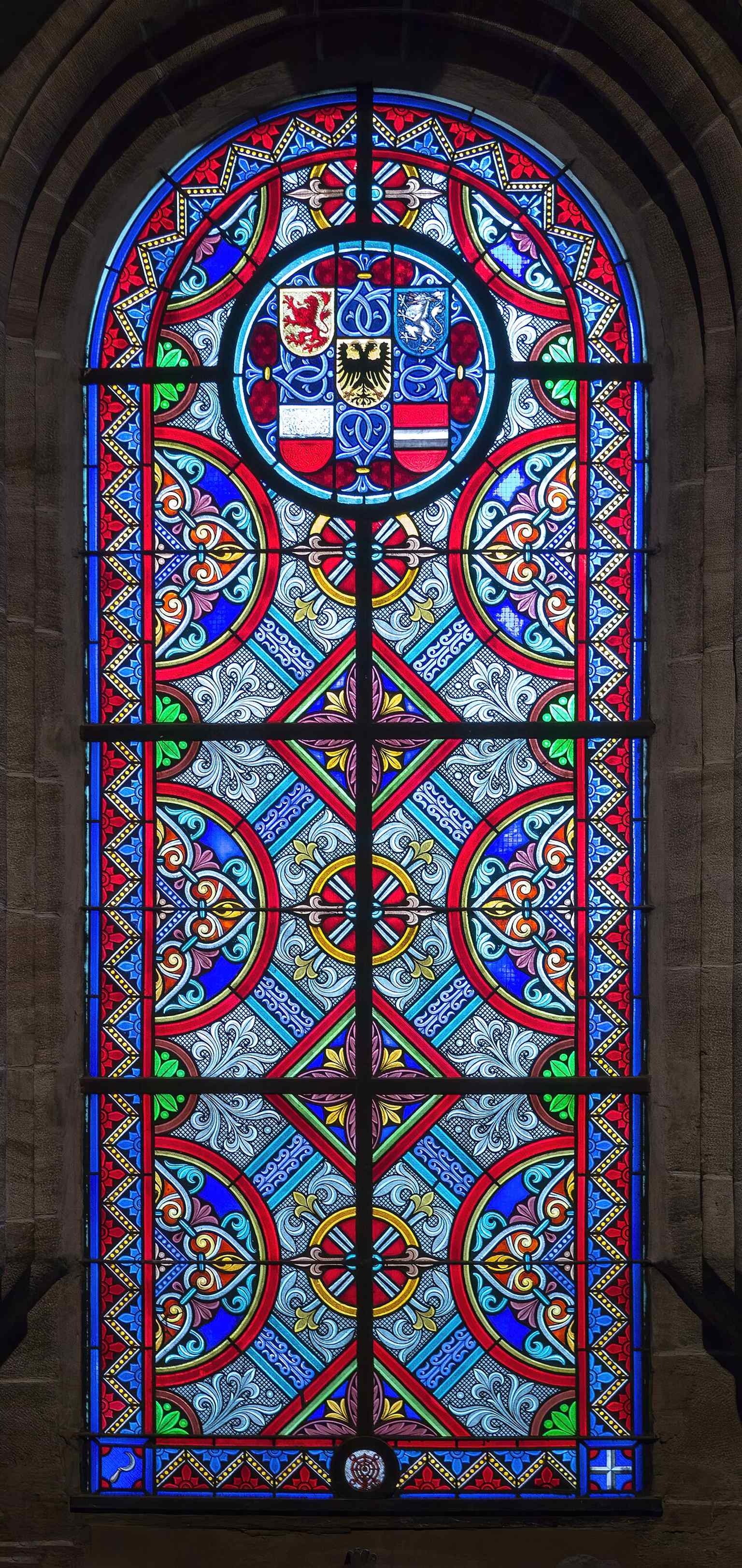 One of the Minster’s stained-glass windows, reflecting the later 19th-century glazing that fills much of the interior light today.