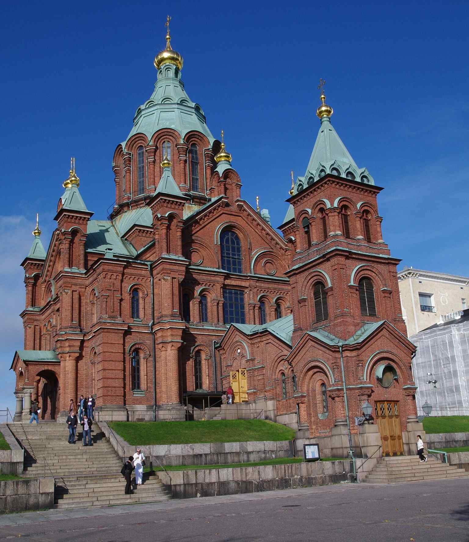 A classic full view of Uspensky Cathedral in red brick and gold, the Helsinki landmark that welcomes hundreds of thousands of visitors each year.
