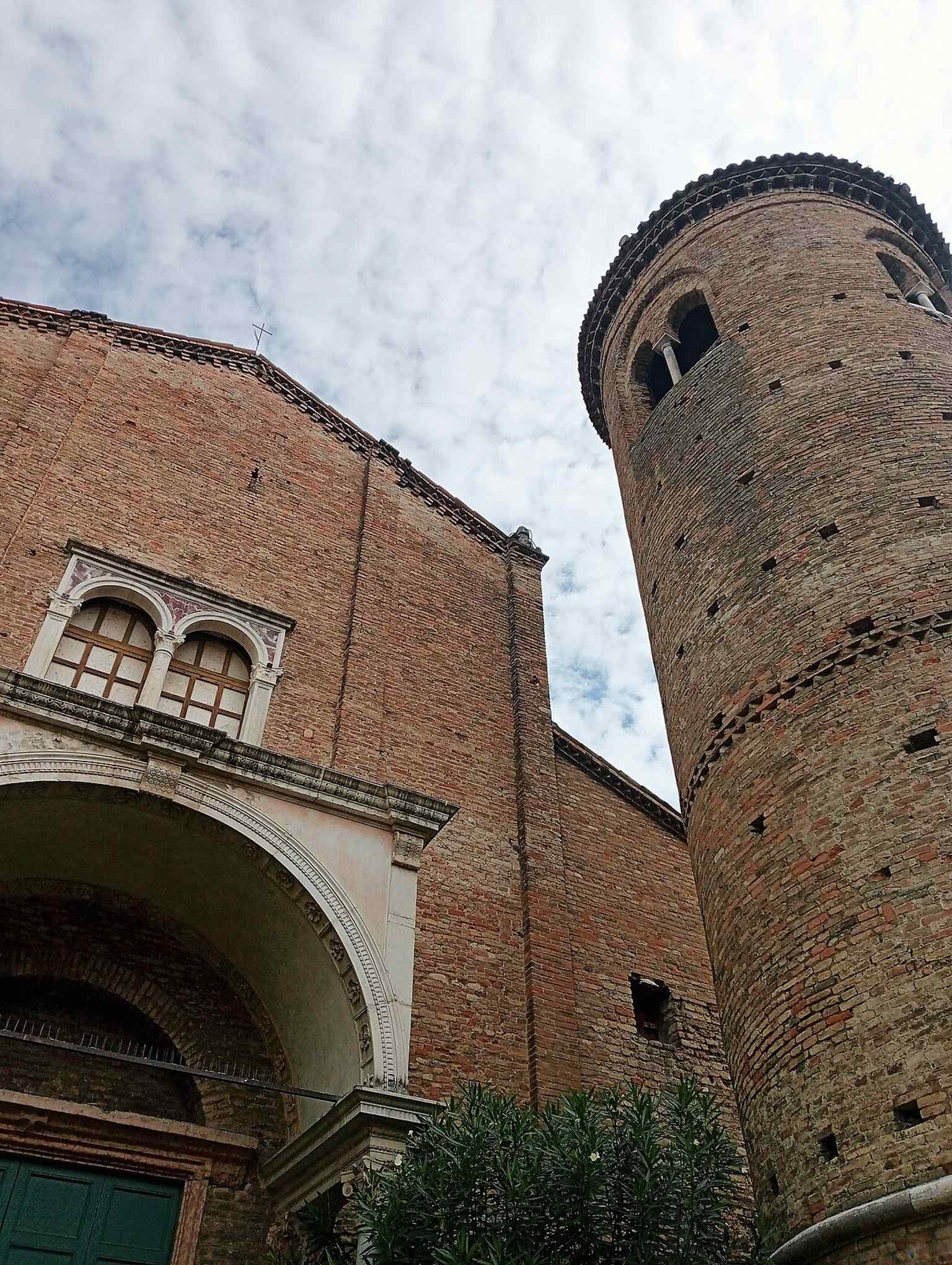 The rebuilt brick facade of Sant'Agata Maggiore, with the detached campanile and garden that once marked the line of the old quadriportico.