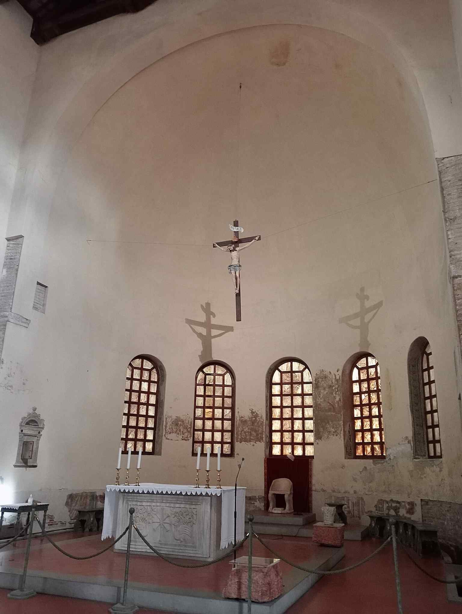 The church interior showing its sparse early-Christian atmosphere, shaped by the 1913–1918 restoration that removed later Baroque additions.