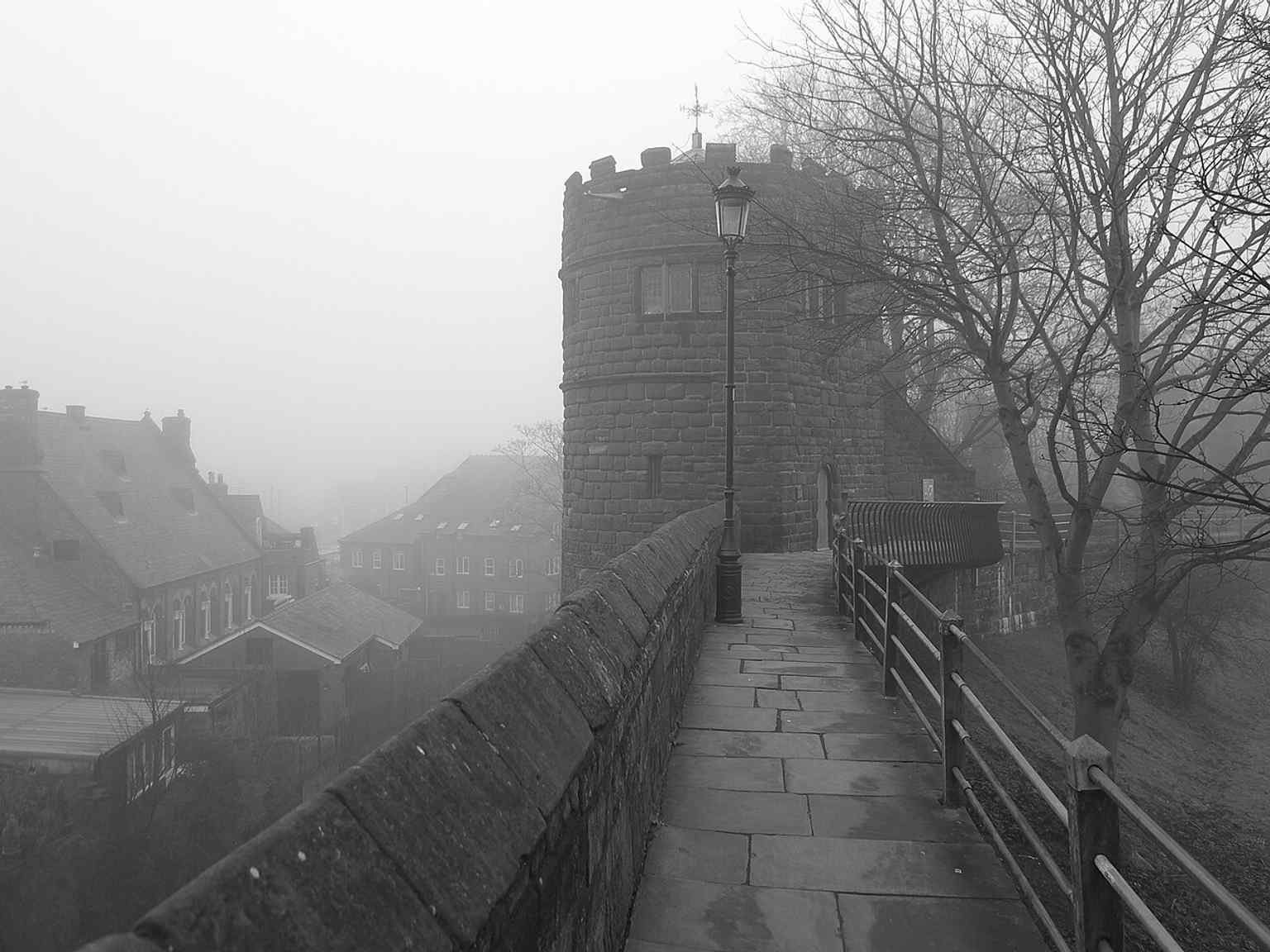 A moody black-and-white view of the tower on the walls, evoking its long history and wartime damage.