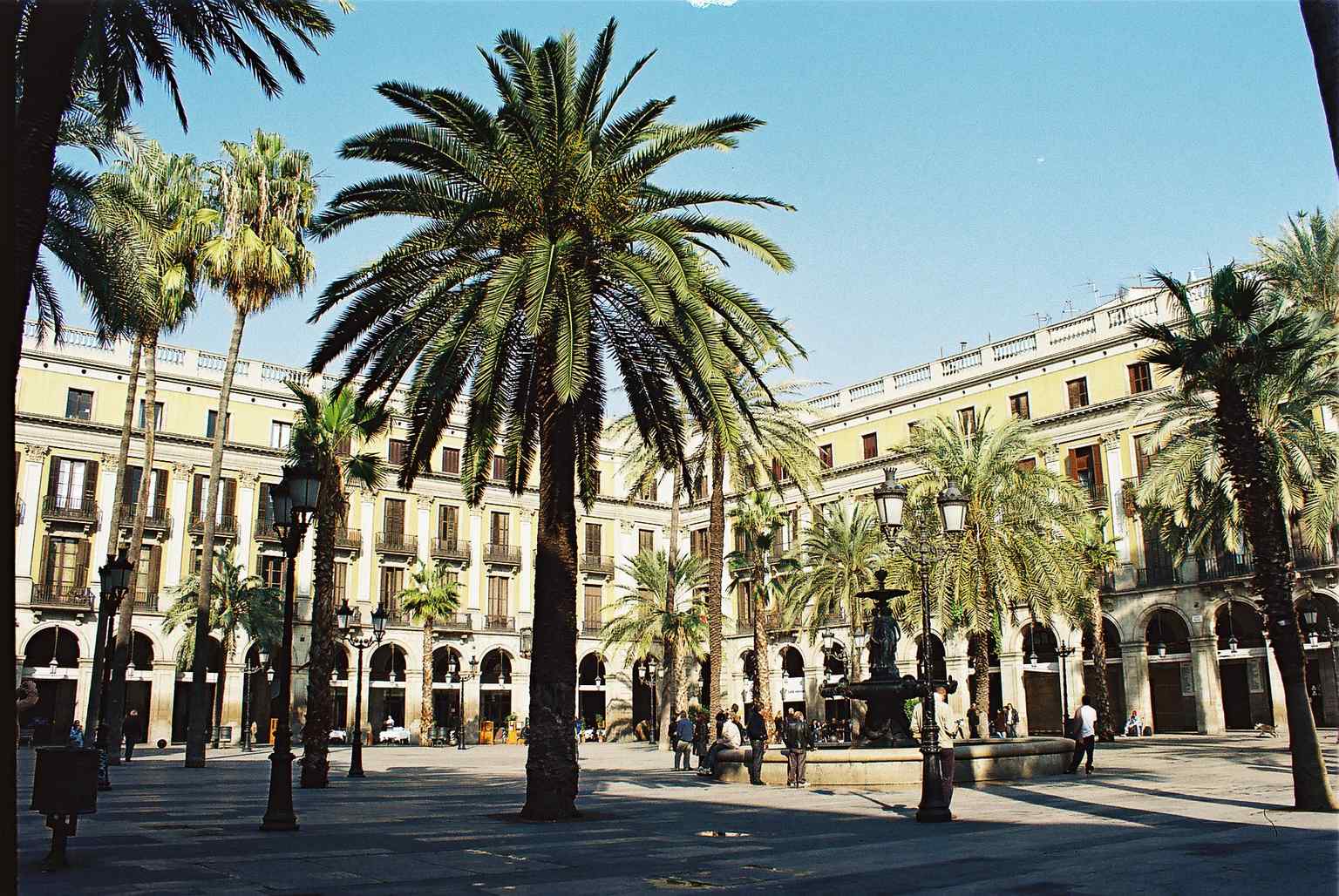 The Fuente de las Tres Gracias, installed in 1876 by Antoine Durenne, sits at the heart of the Plaça Reial, replacing an earlier, unpopular monument.
