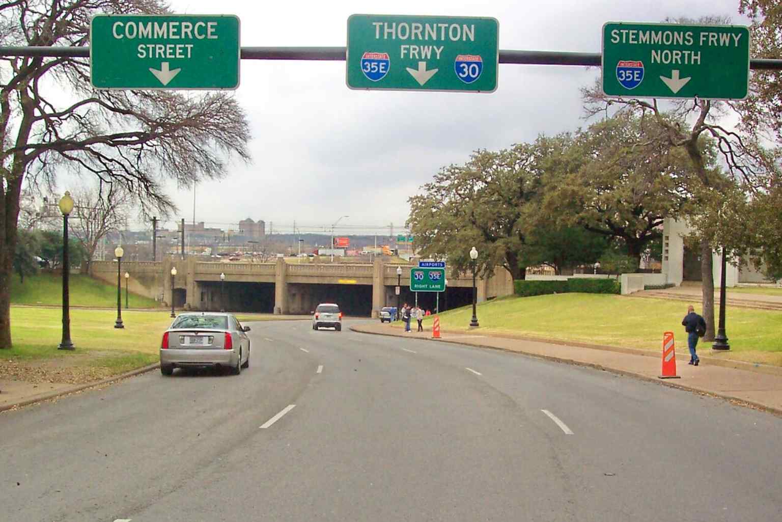 Elm Street’s Triple Underpass and grassy knoll show the key western edge of the plaza where the motorcade passed after the shots.