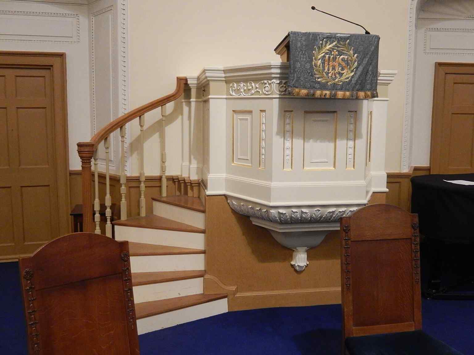 The pulpit stands on the north wall, matching the church’s distinctive elliptical layout and historic preaching arrangement.