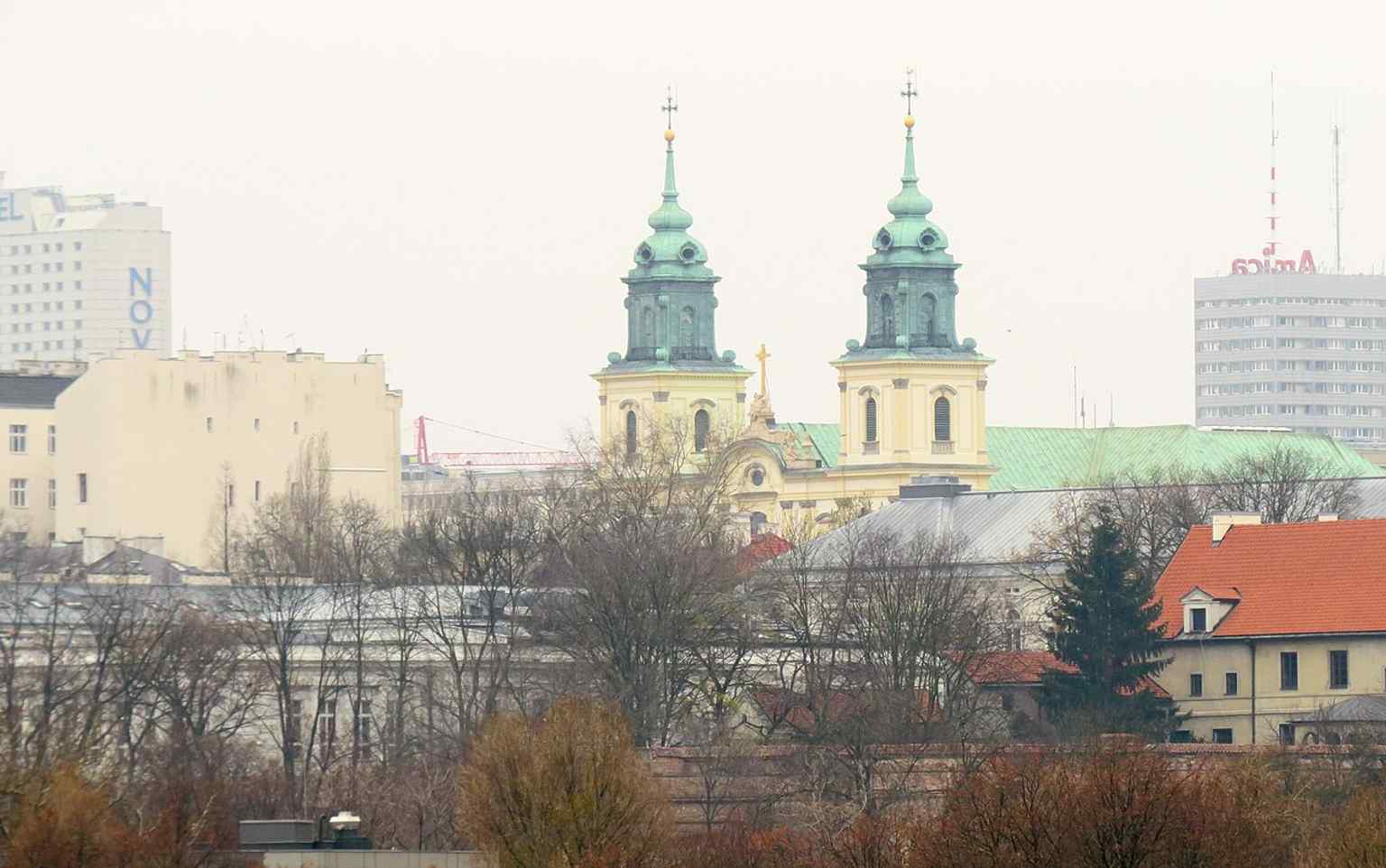 A wider city view from across the Vistula, placing the basilica in Warsaw’s skyline near the historic royal route.
