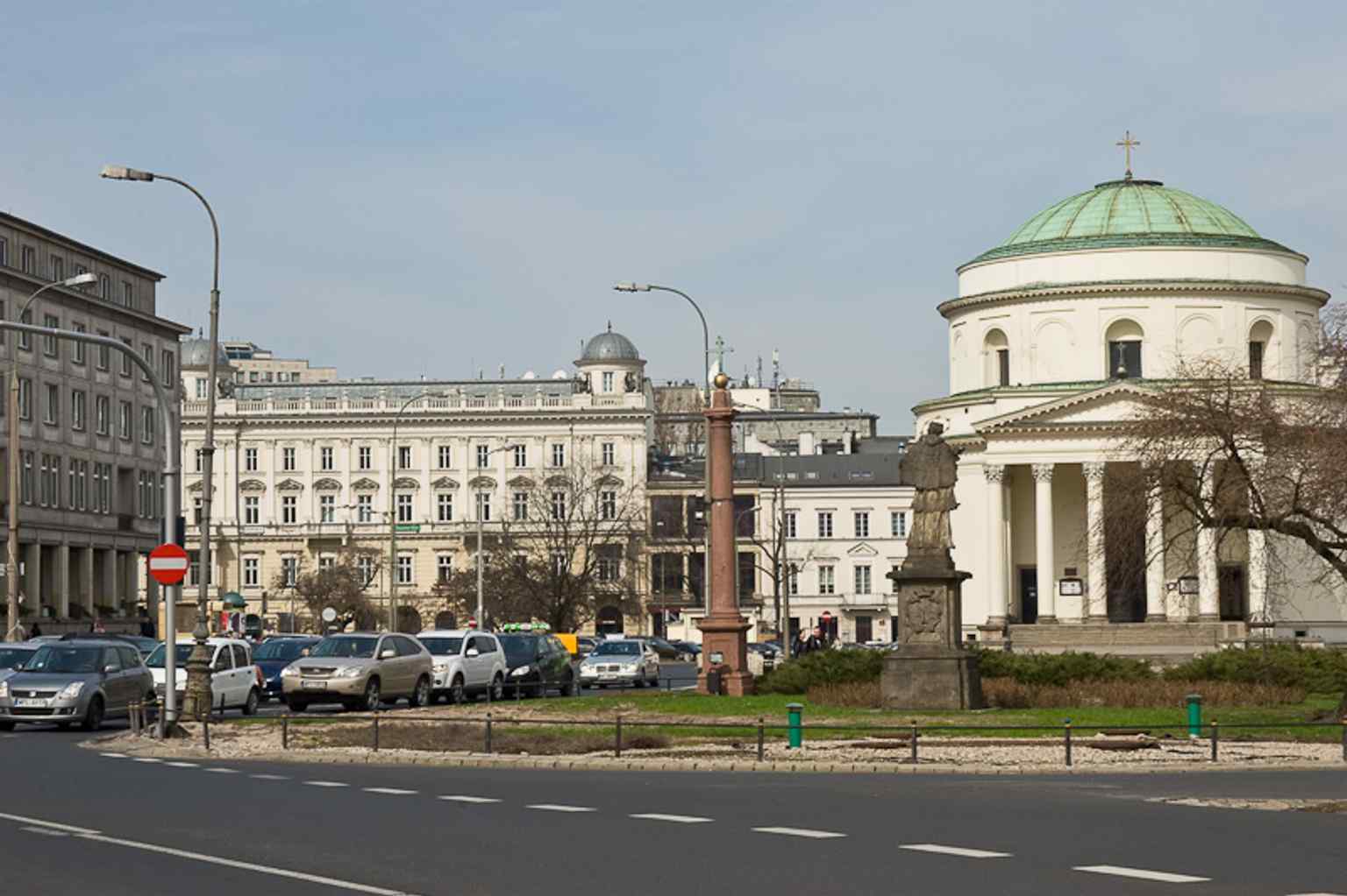 Kamienica Pod Gryfami at the square’s edge, part of the dense 19th-century frontage around Plac Trzech Krzyży.