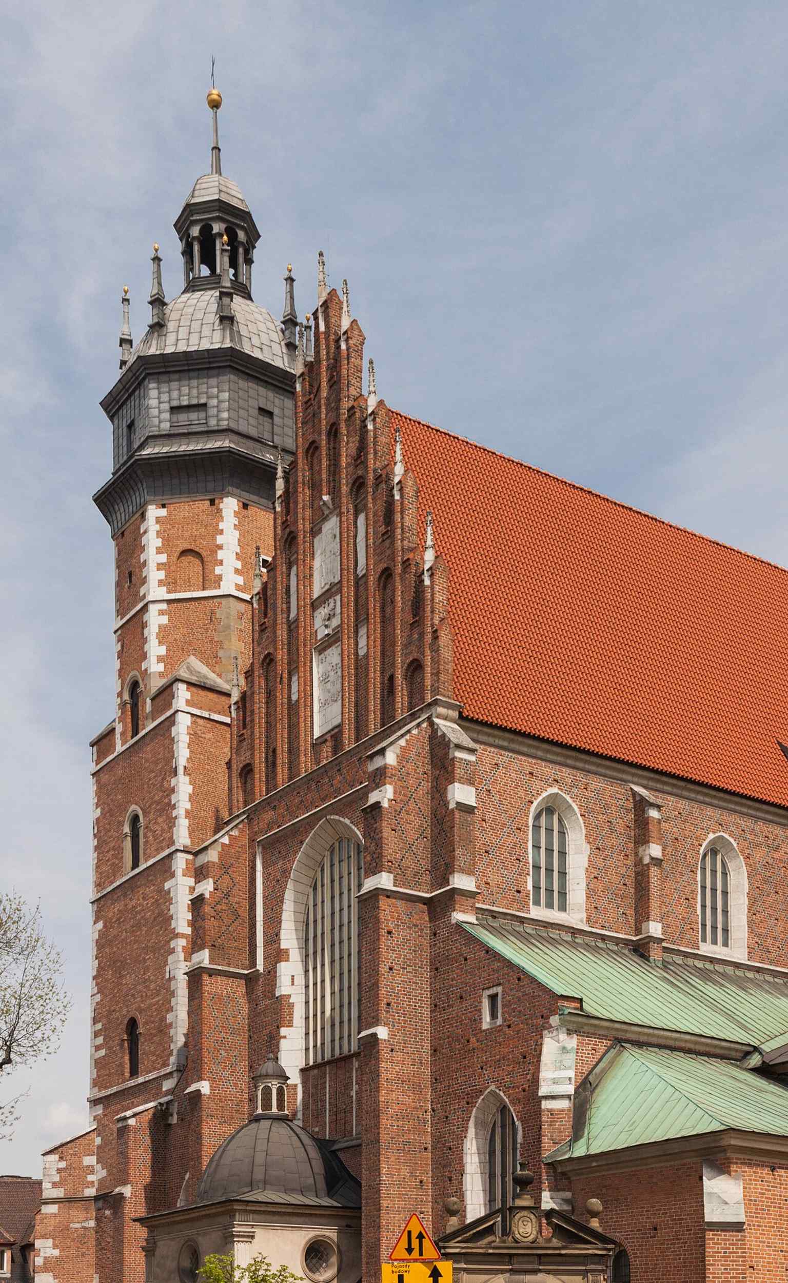 A side view of the basilica’s brick massing, useful for showing how the church’s façade and nave were completed after centuries of building.
