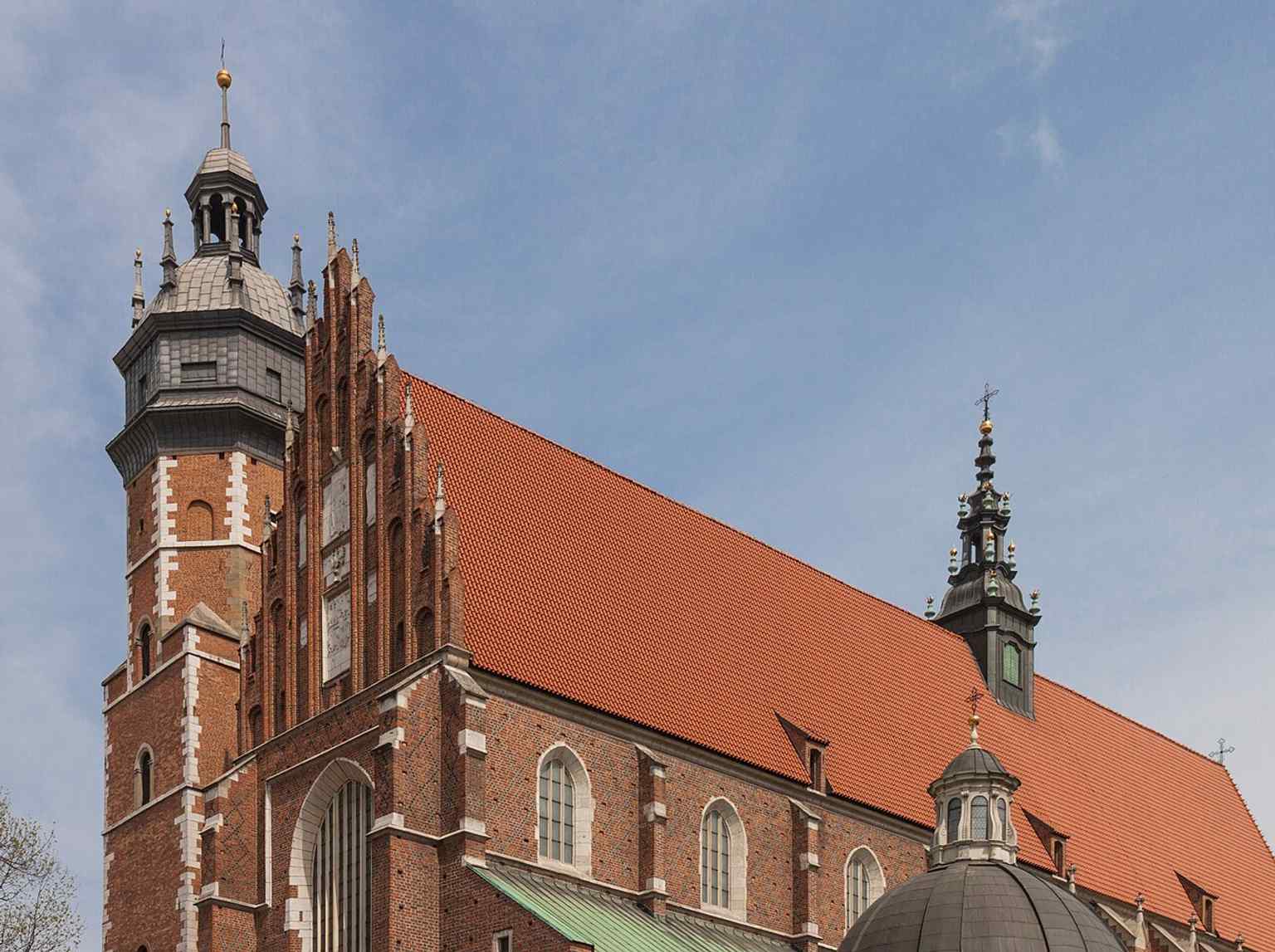 A strong exterior perspective highlighting the church’s tall brick silhouette in Kazimierz, where royal patronage and monastic life met.
