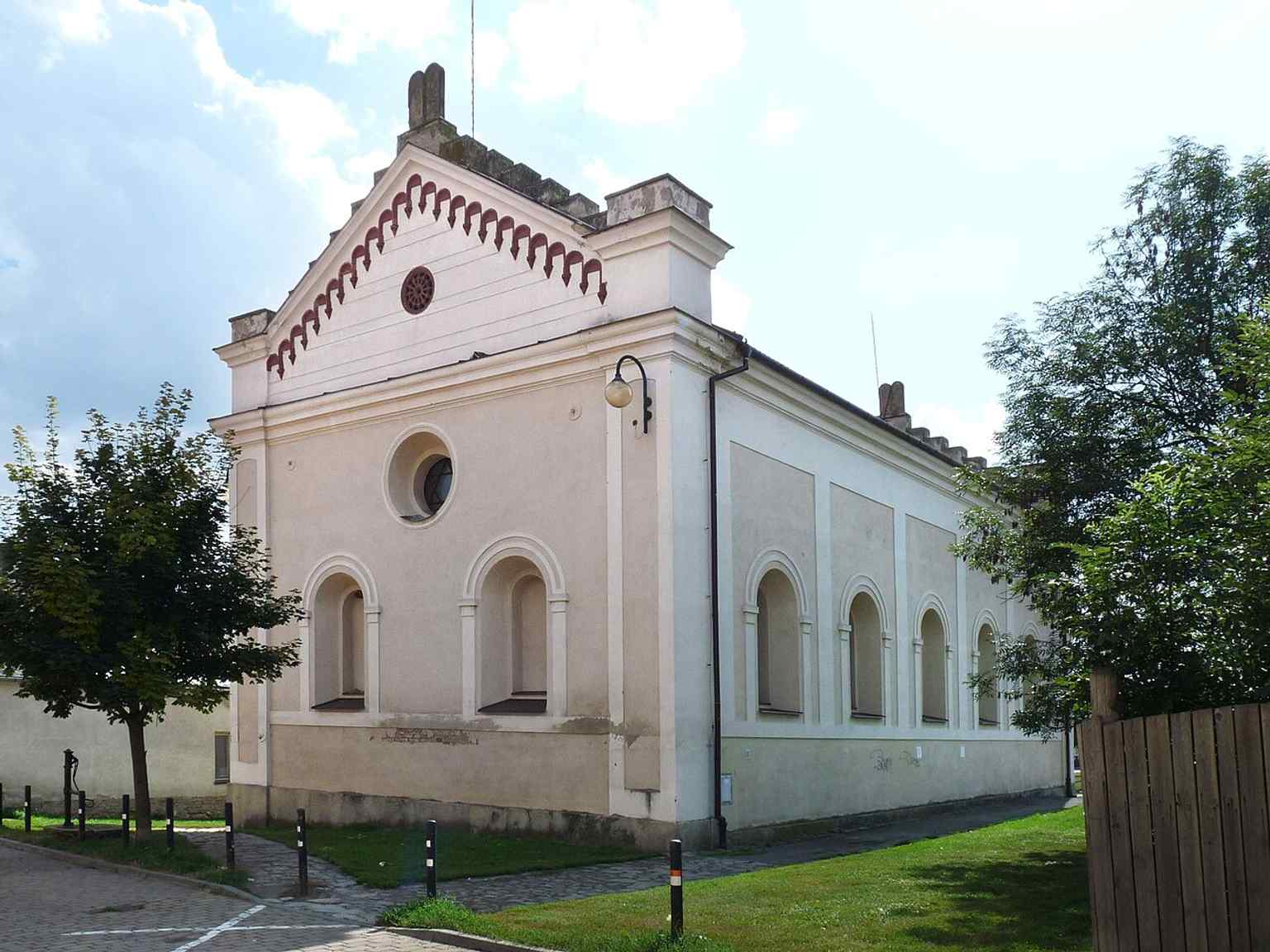 This view of the former synagogue showcases its Neo-Romanesque style, built between 1857-1858, and now serves as a protected cultural monument and a depository for the State District Archive Vyškov.