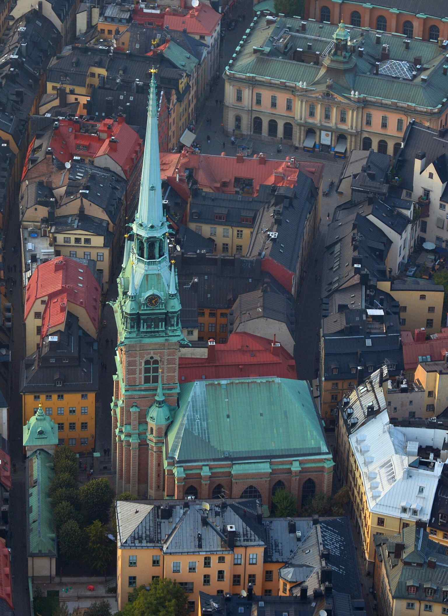 Aerial view of the church within the roofscape of Gamla stan — useful for showing how the tower dominates Stockholm’s skyline.