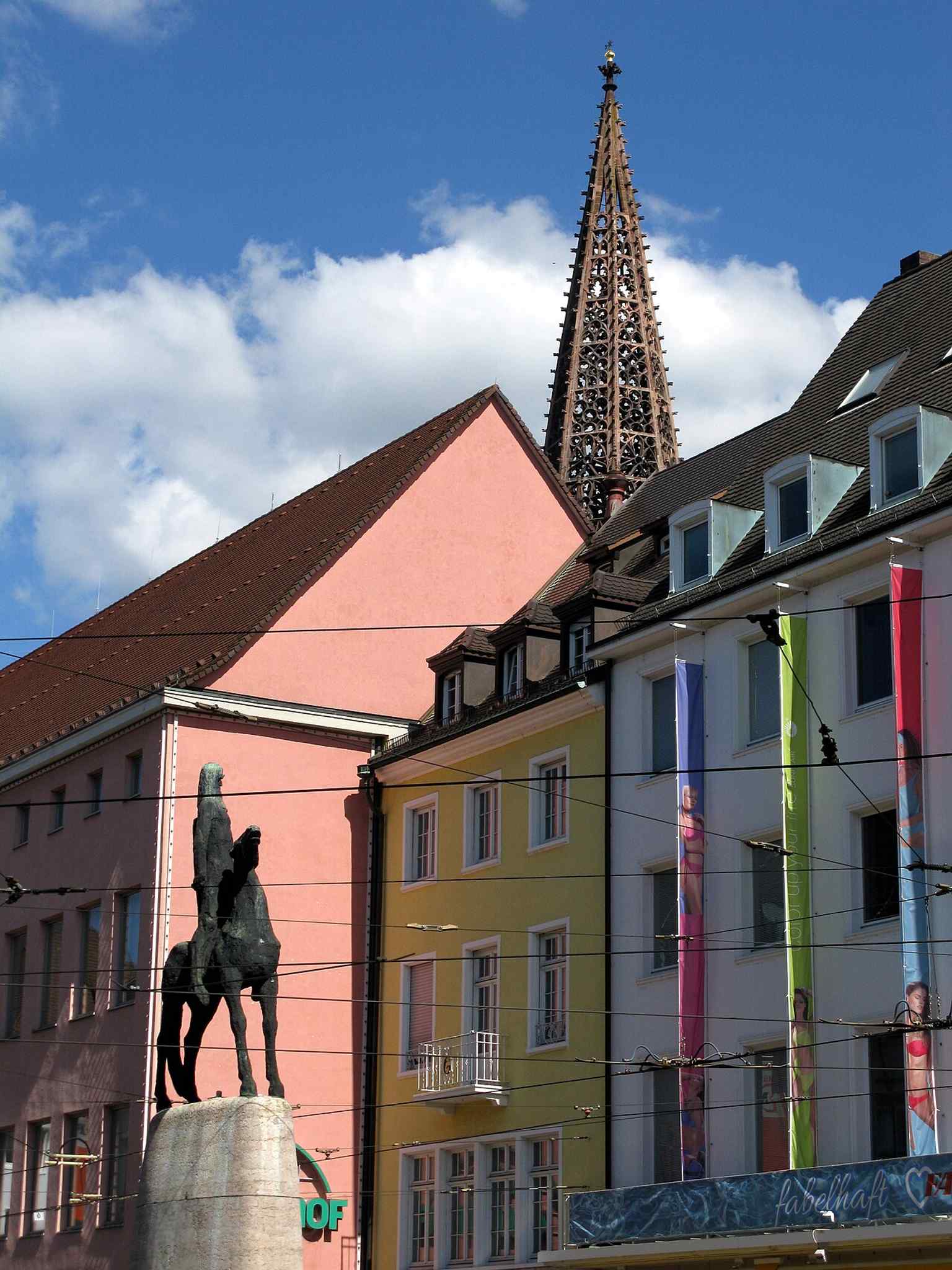 The fountain with Freiburg Minster in the background, linking the modern monument to the city’s medieval heritage.