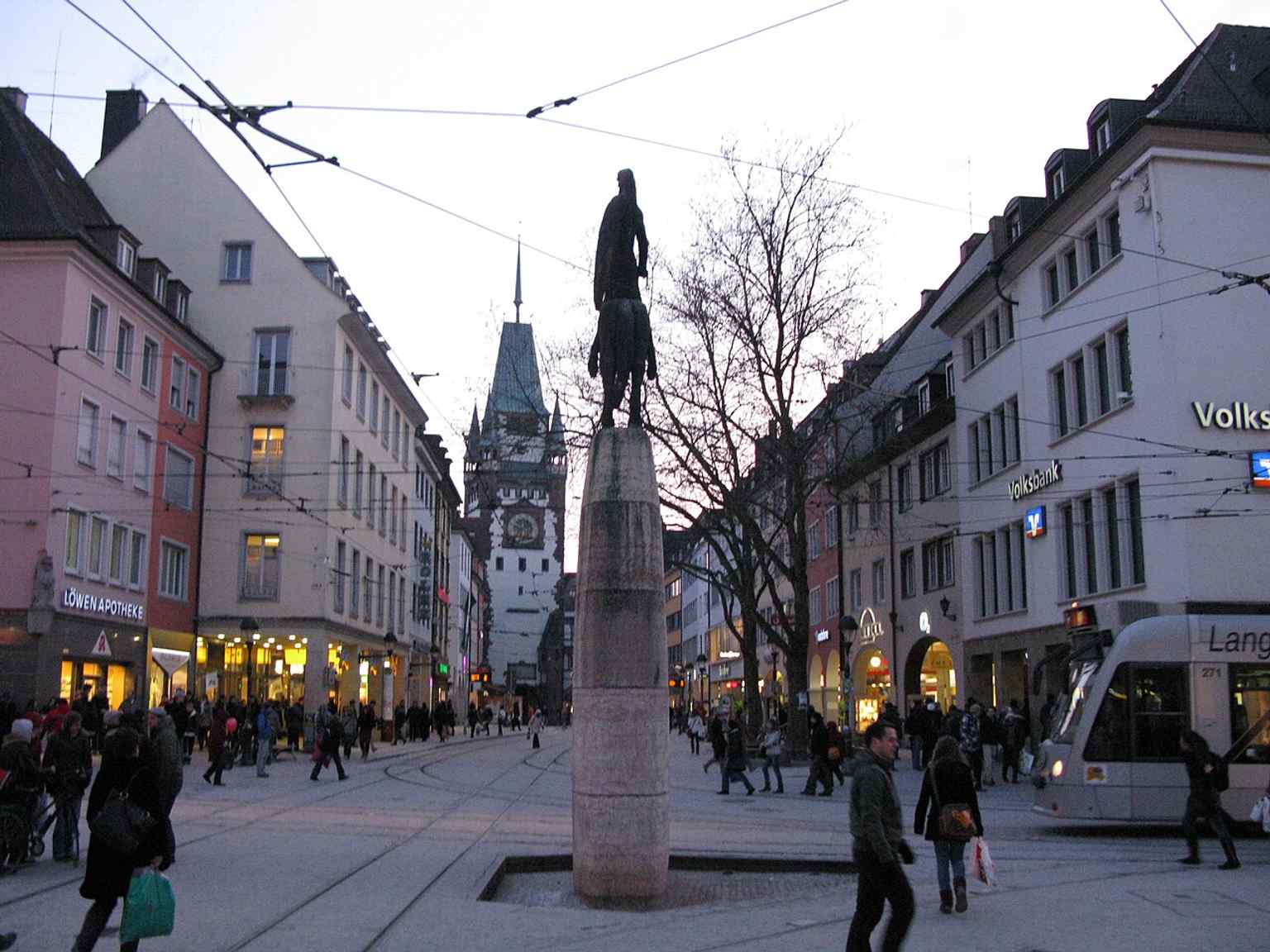 The fountain on Kaiser-Joseph-Straße with Martinstor in the background, placing Bertoldsbrunnen within Freiburg’s historic core.