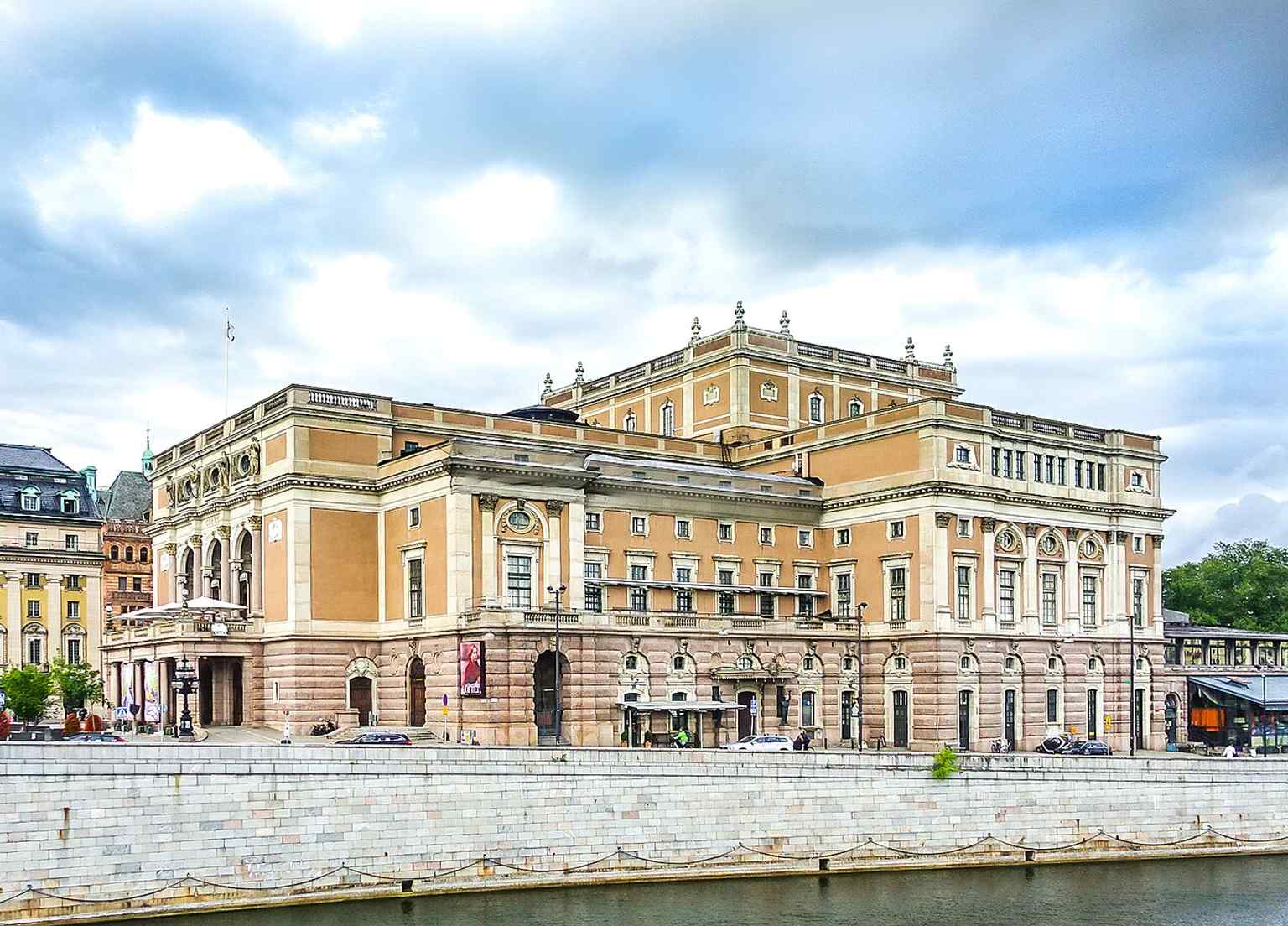 A view of the Royal Swedish Opera from Norrbro, highlighting its prominent location in central Stockholm, nestled between Gustav Adolfs torg and Kungsträdgården.