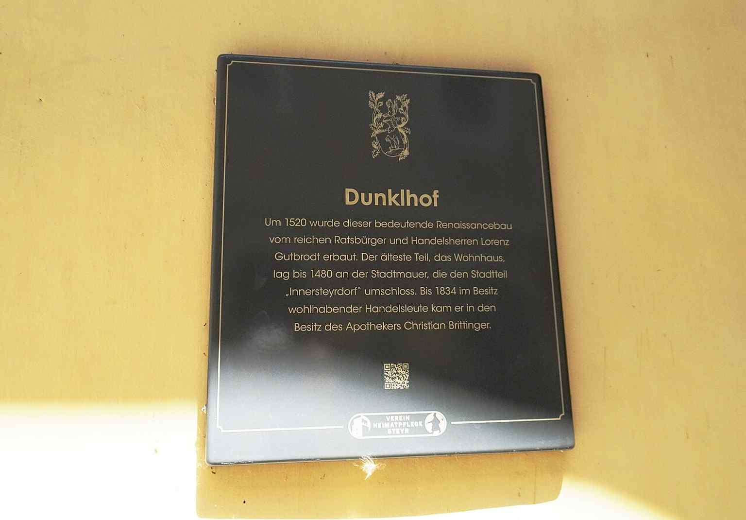 A full exterior view of the Dunklhof captures the building’s historic presence along Kirchengasse, where its upper floor projects beyond the ground floor.