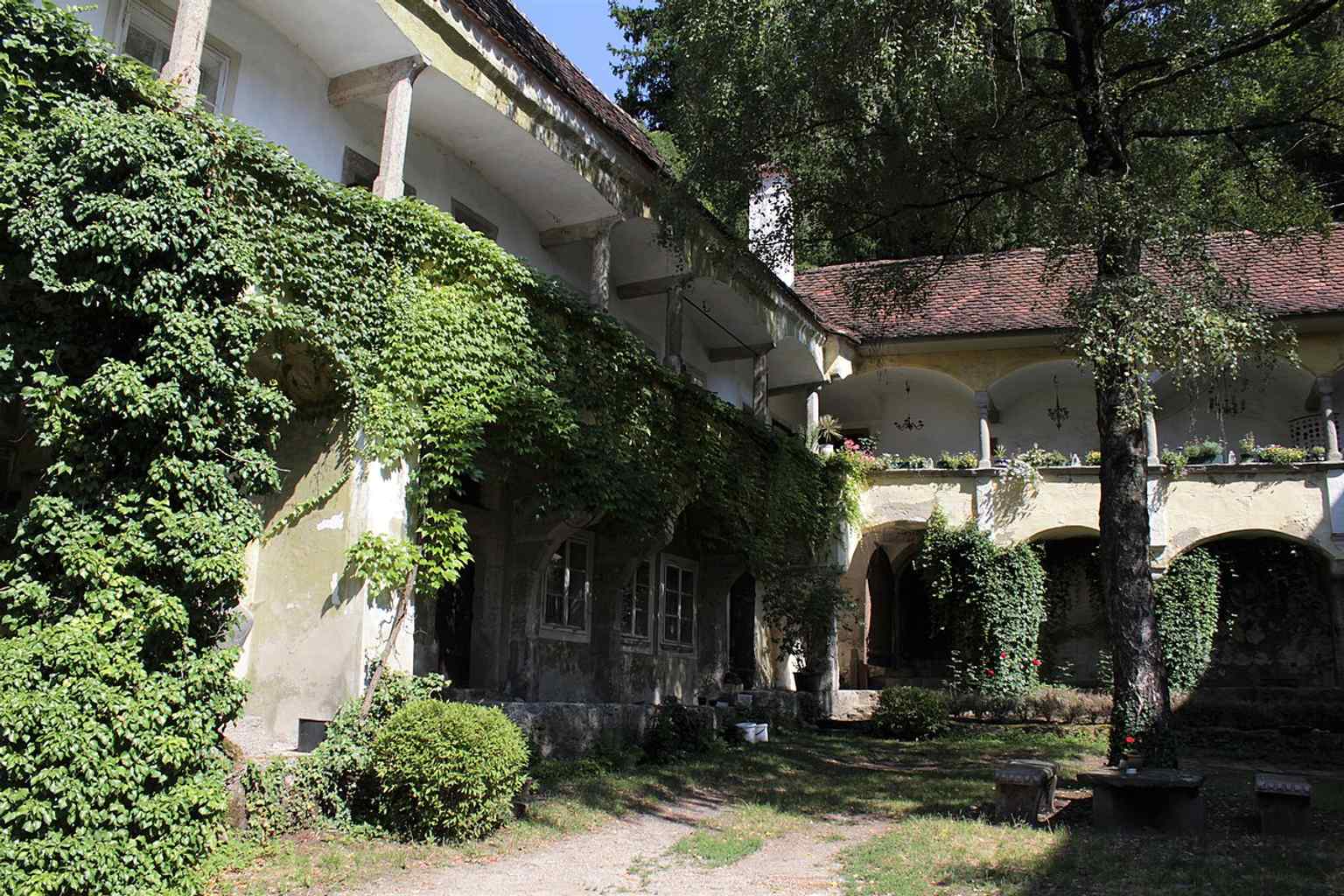This Renaissance courtyard view highlights the elegant arcade structure dating to around 1520/25, with the decorative columns mentioned in the history.