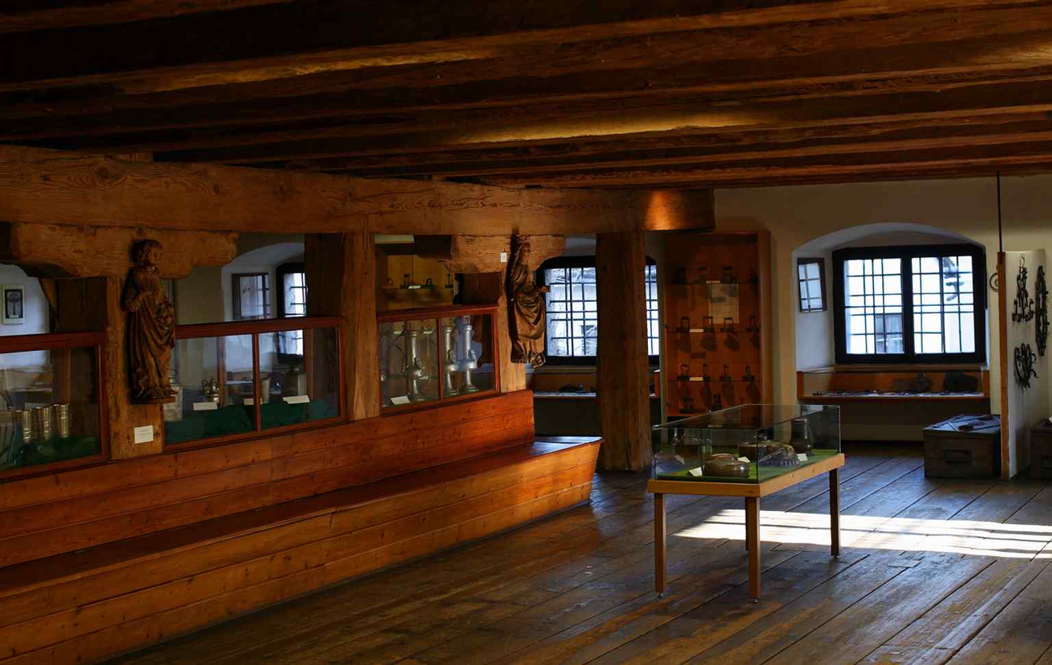 A museum room inside the former storehouse, where the sturdy wooden beam ceiling reflects the building’s practical Renaissance function.
