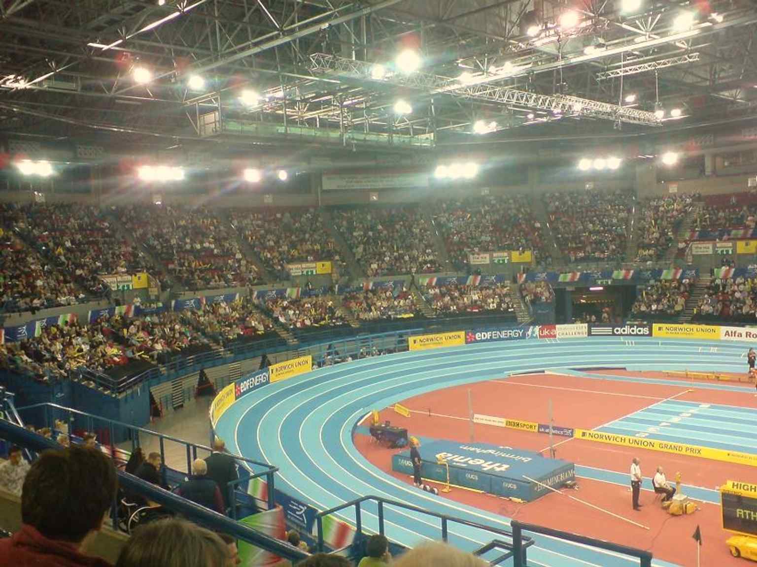 An athletics meeting inside the National Indoor Arena, showing the kind of world-class indoor competition the venue was built to host.