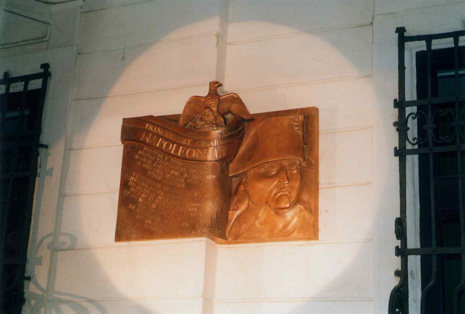 The commemorative plaque on the palace wall recalls Napoleon’s visits and the building’s role as a place of historical memory.