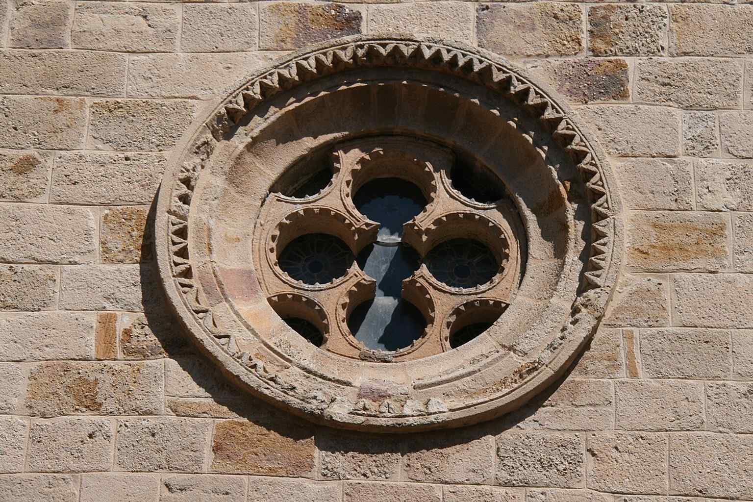 The rose window recalls the church’s refined Romanesque stonework, often compared with the Temple Church in London.