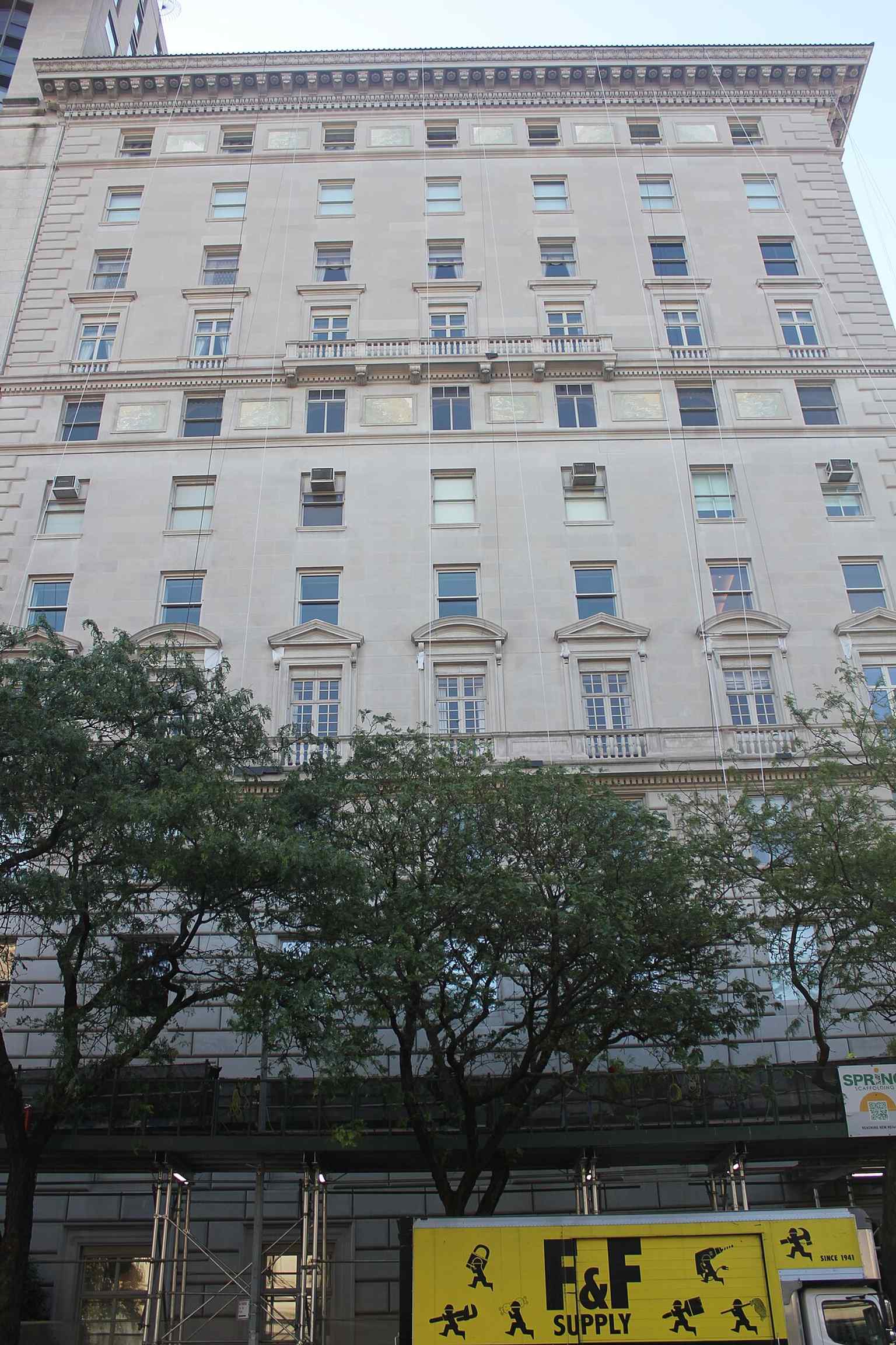 Architectural details of the facade, including window pediments and prominent horizontal moldings, showcasing the building's Italian Renaissance inspiration.
