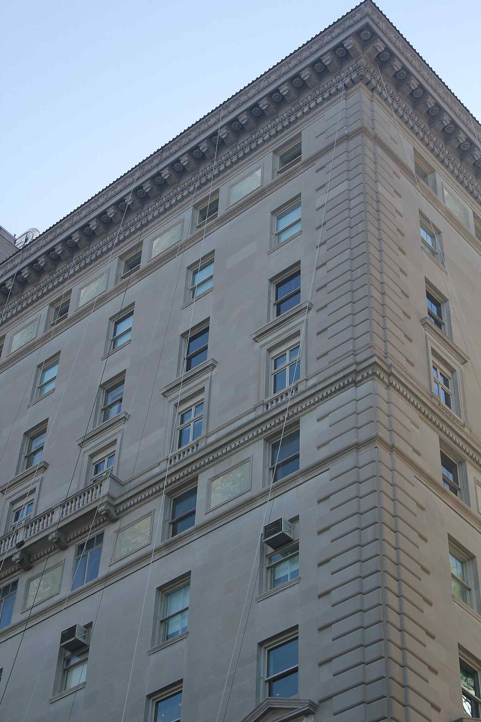 Decorative panels featuring escutcheons and light-yellow marble, which adorn the structure horizontally at four-floor intervals, adding to its luxurious aesthetic.