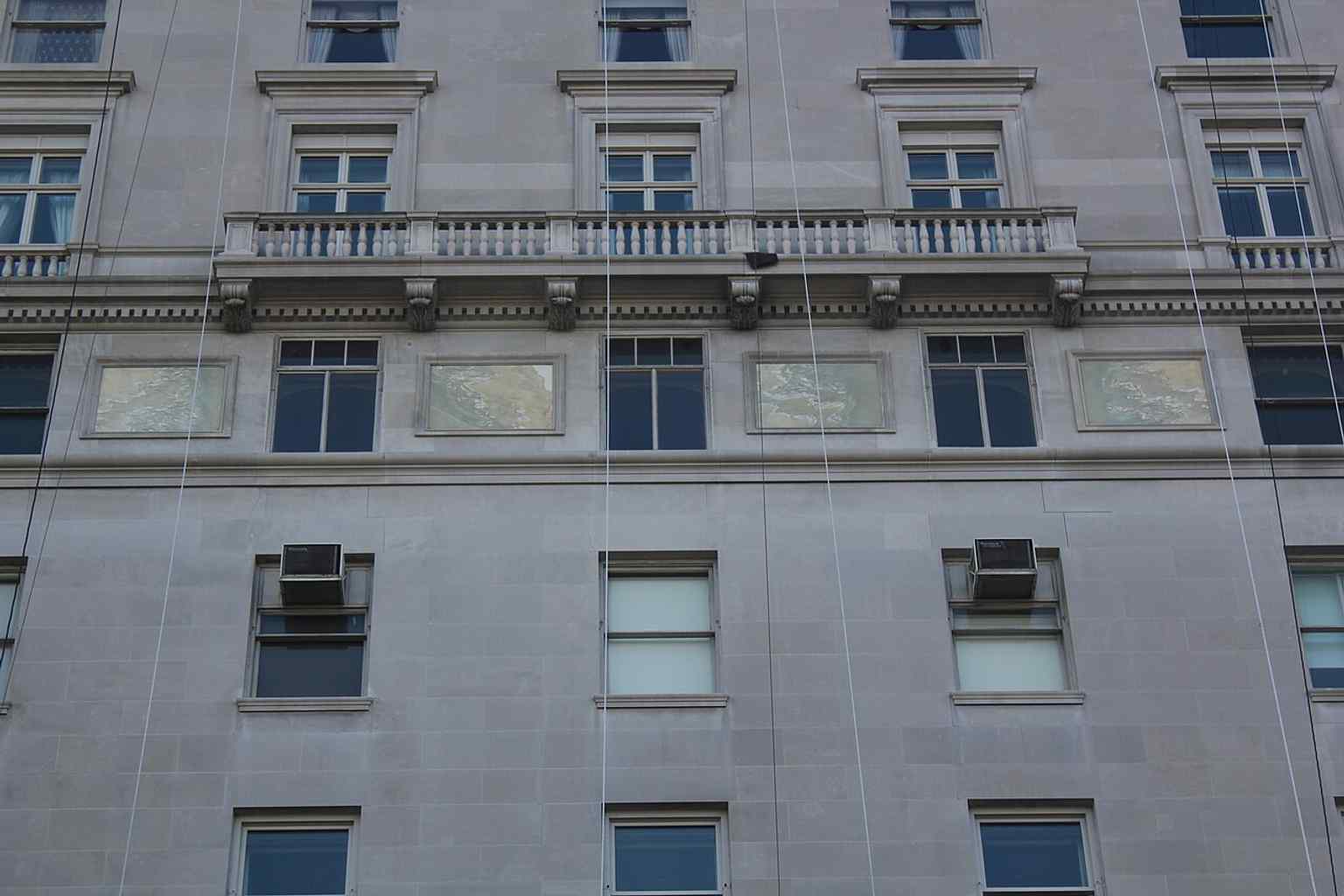 A detail of the upper facade with its pronounced horizontal moldings, which some early architectural critics famously disparaged as 'sliced-off Tootsie Rolls'.