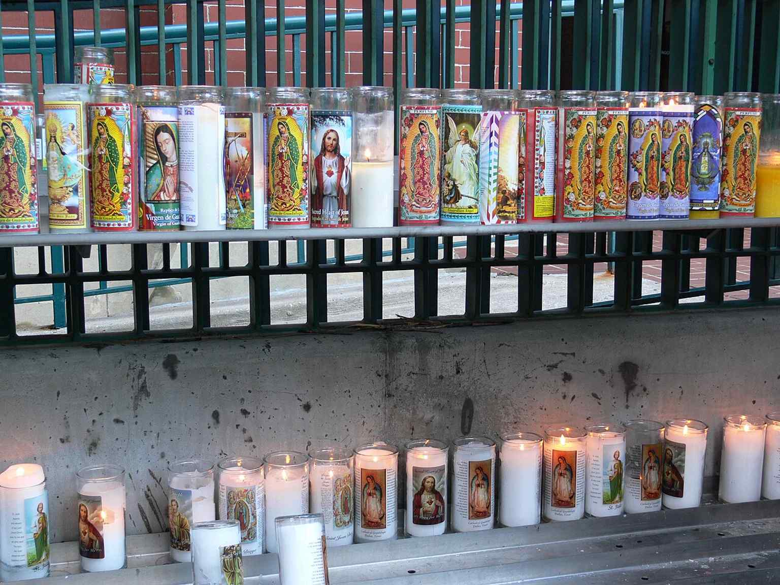 Votive candles beside the Guadalupe statue, reflecting the shrine’s deep devotional life and immigrant heritage.