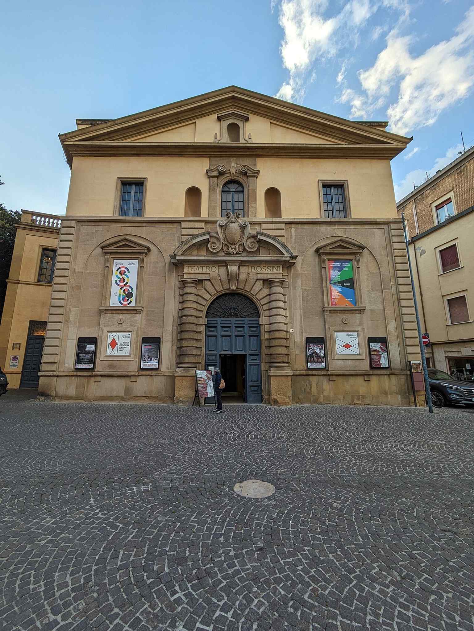 A clear street view of Teatro Rossini, whose current name honors Gioachino Rossini, born in Pesaro and first celebrated here in 1818.