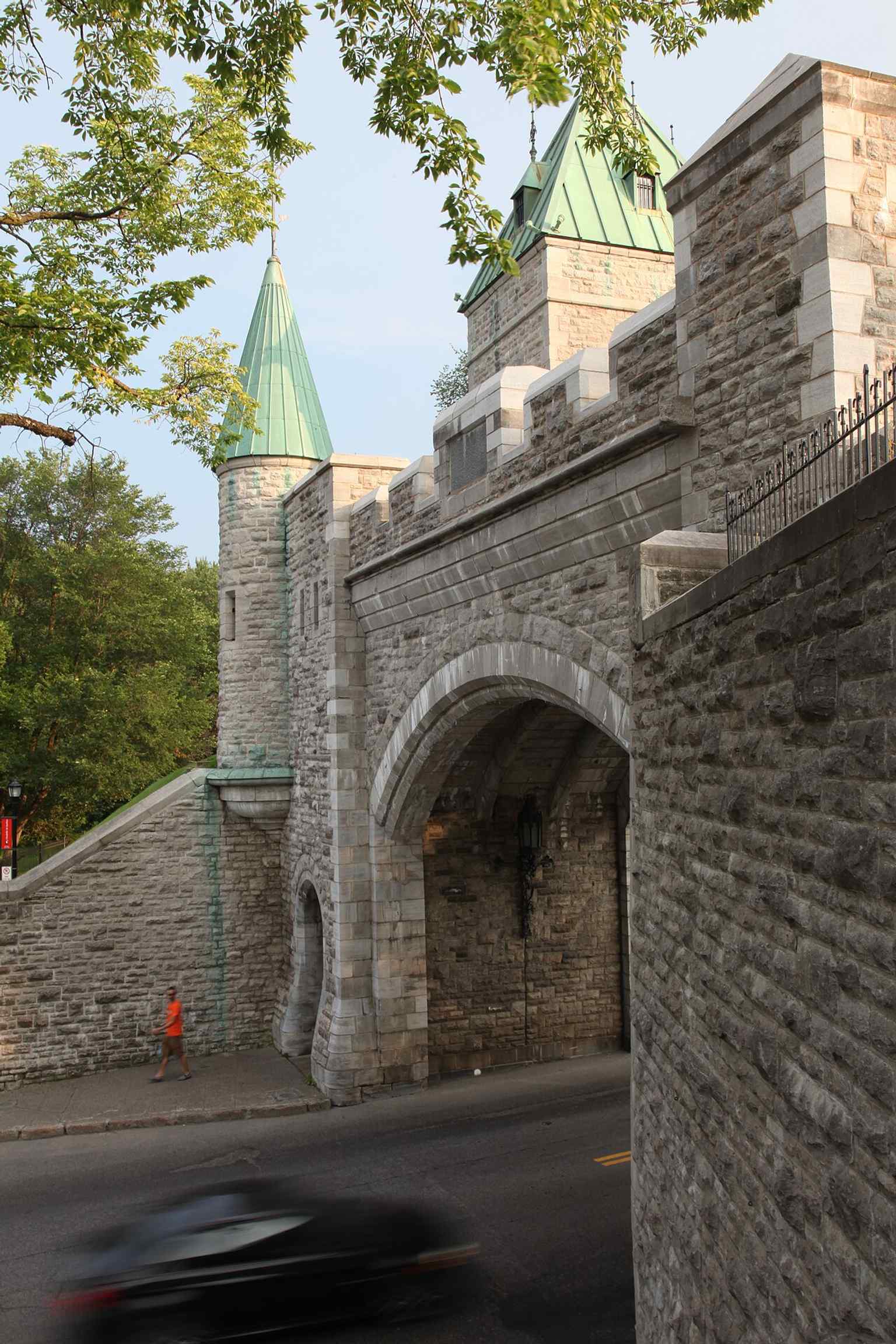 Porte Saint-Louis beside the historic site’s signage connects the gate to the wider Fortifications National Historic Site and its many linked defense structures.