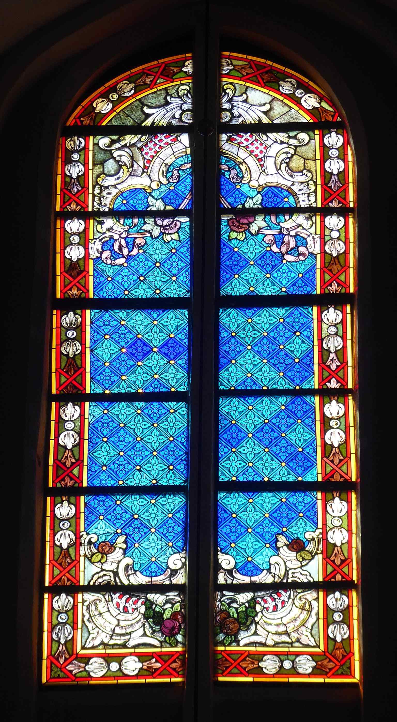 A stained-glass window from the church interior, part of the restored fabric revealed in the 1970s restoration campaign.