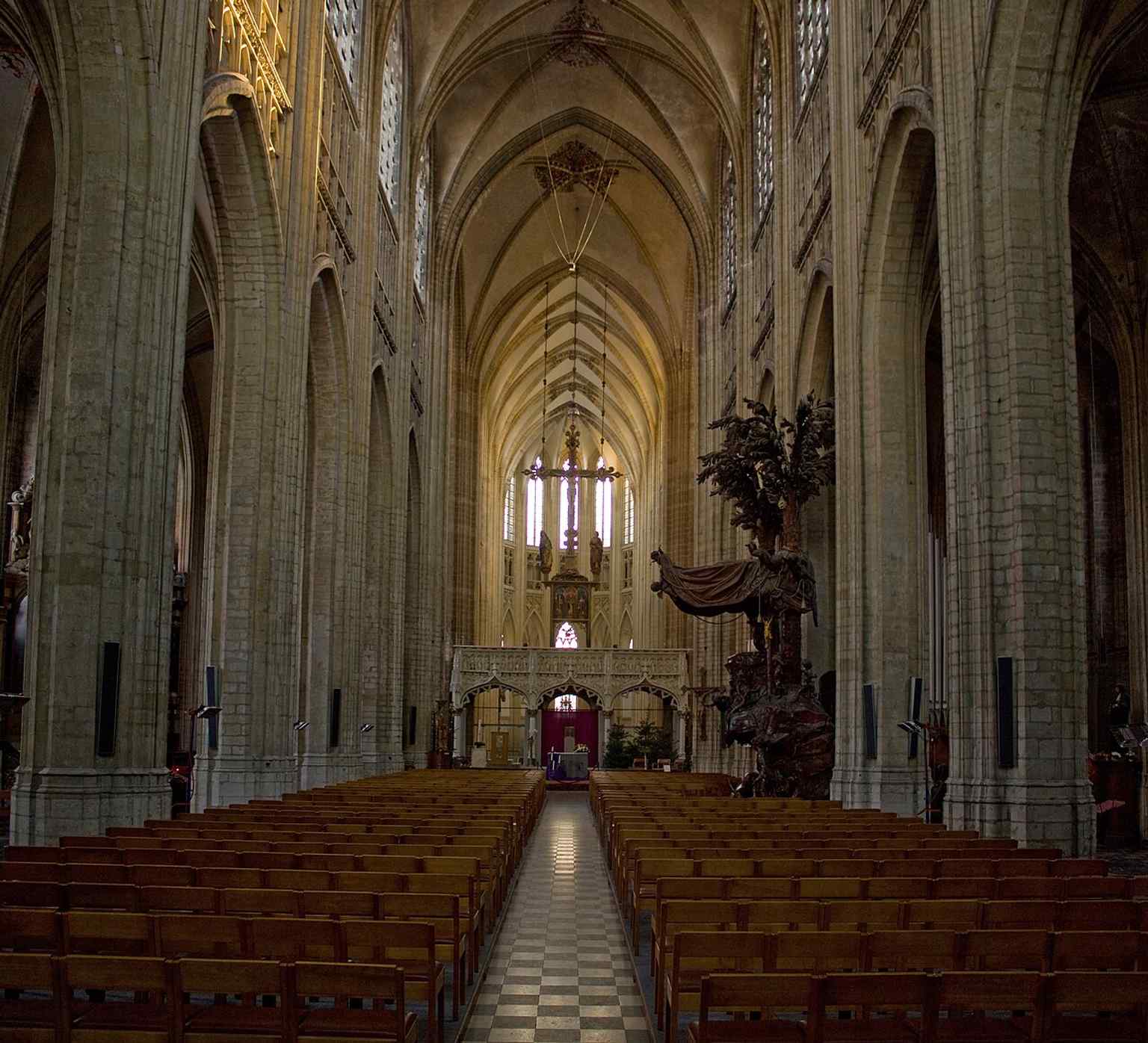 The nave interior conveys the scale of the three-aisled basilica and the restored postwar church space.