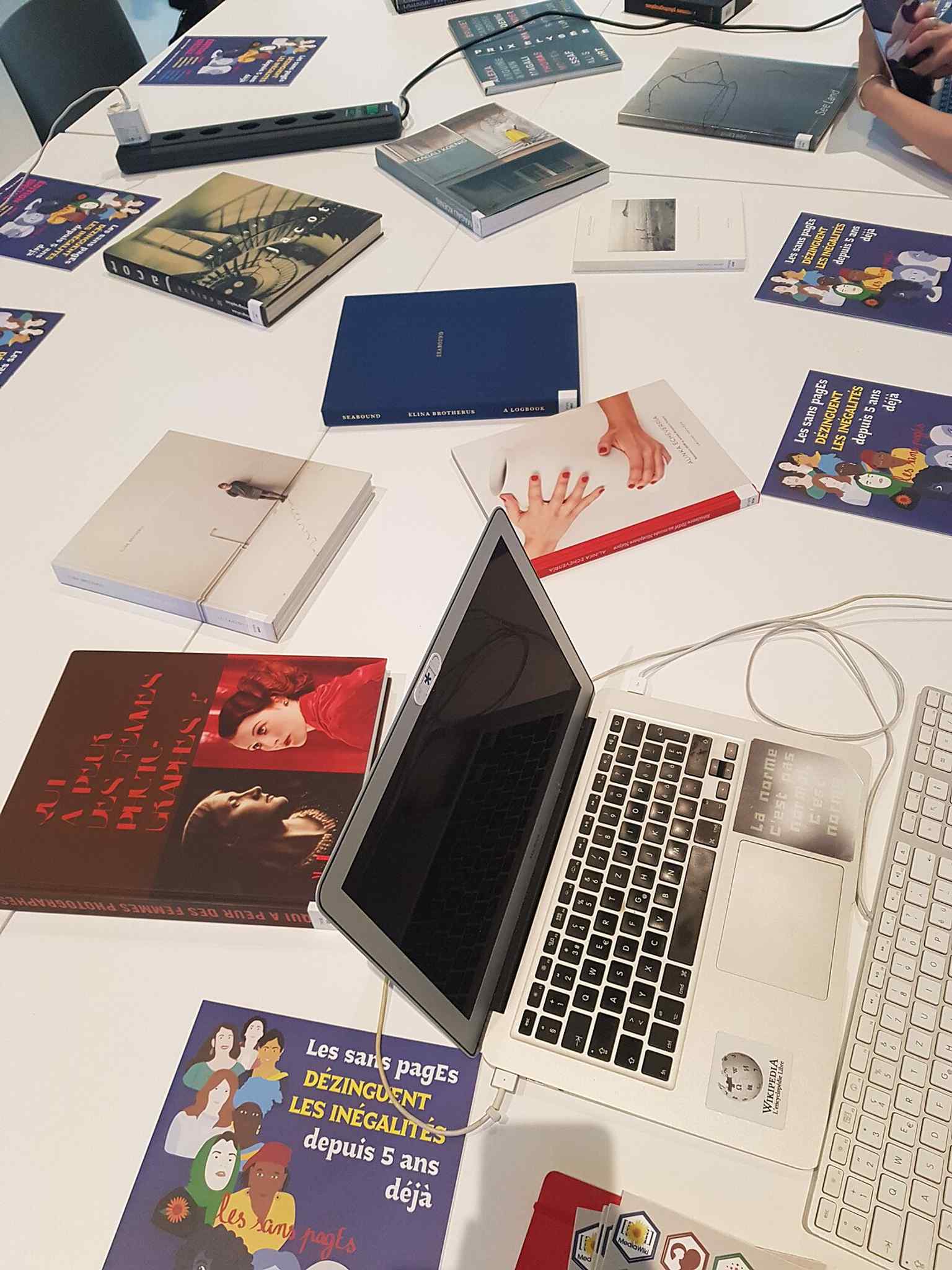 A workshop table filled with books and zines, echoing Photo Elysée’s public programming and photography culture activities.