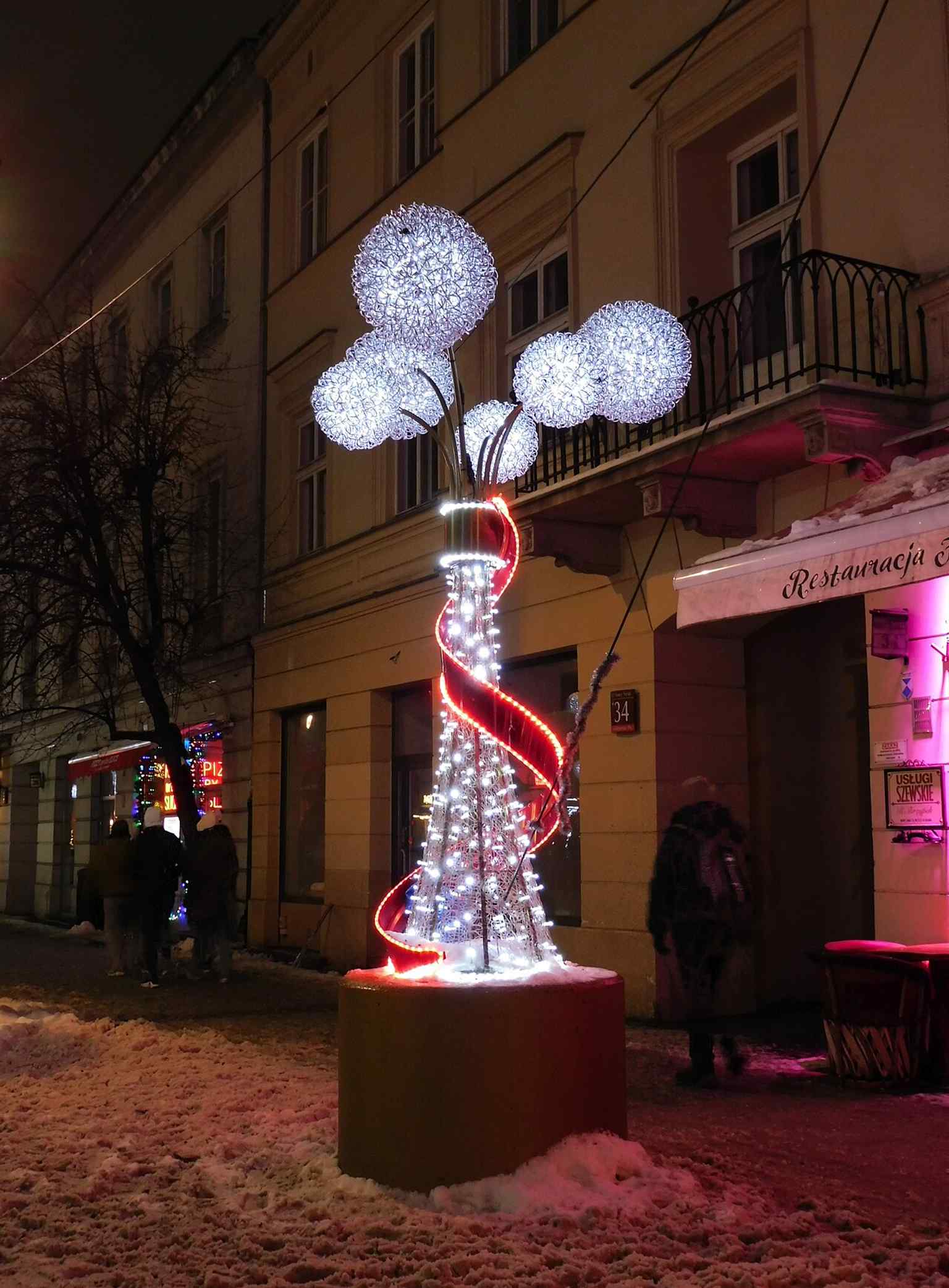 A winter 2026 view of the decorated street, capturing Nowy Świat as a contemporary promenade rather than a traffic corridor.