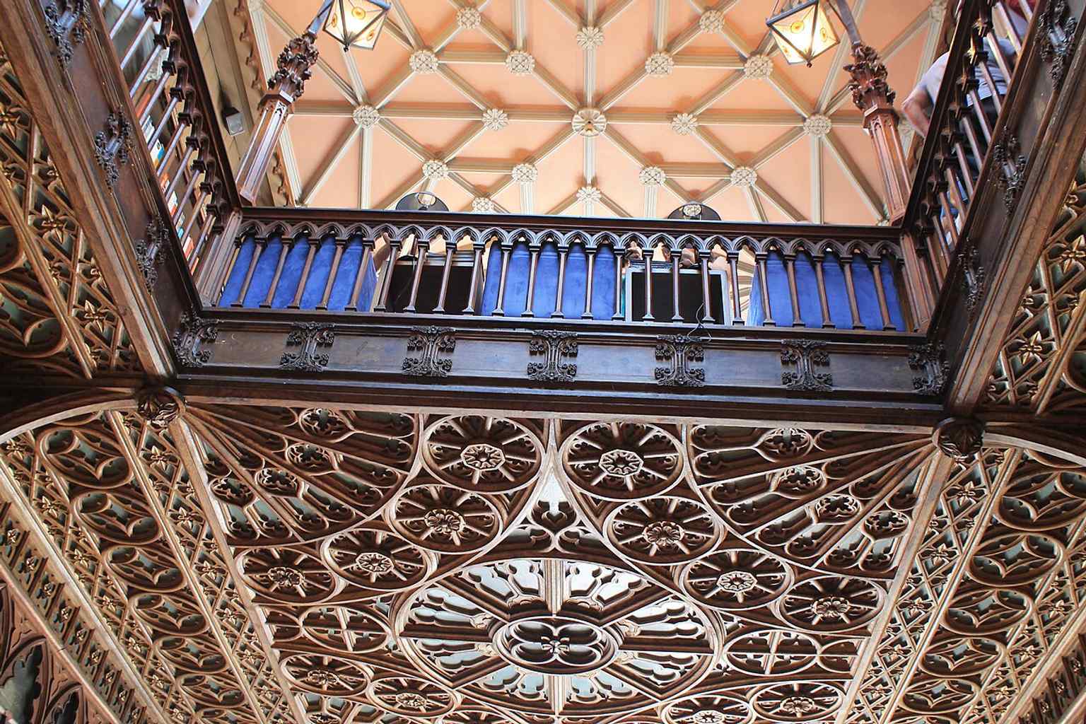 An elegant interior perspective showing the layered bookshelves and neo-Gothic detailing that make the shop feel more like a literary monument.