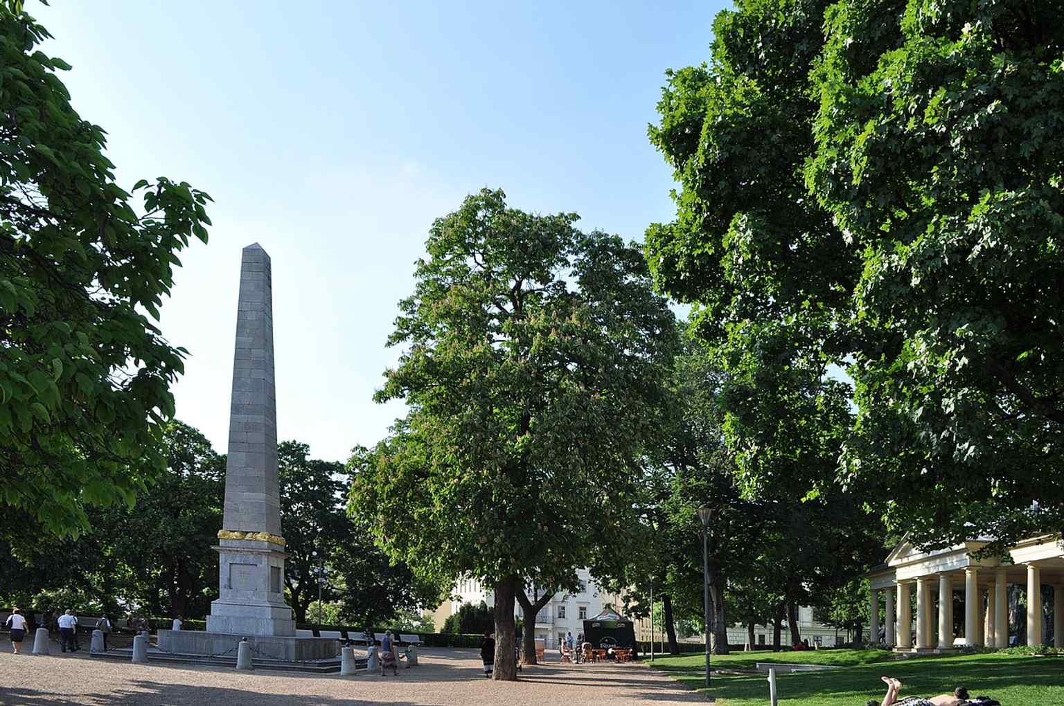 The obelisk and colonnade together — the park’s best-known klasicist ensemble, created to commemorate the end of the Napoleonic Wars.