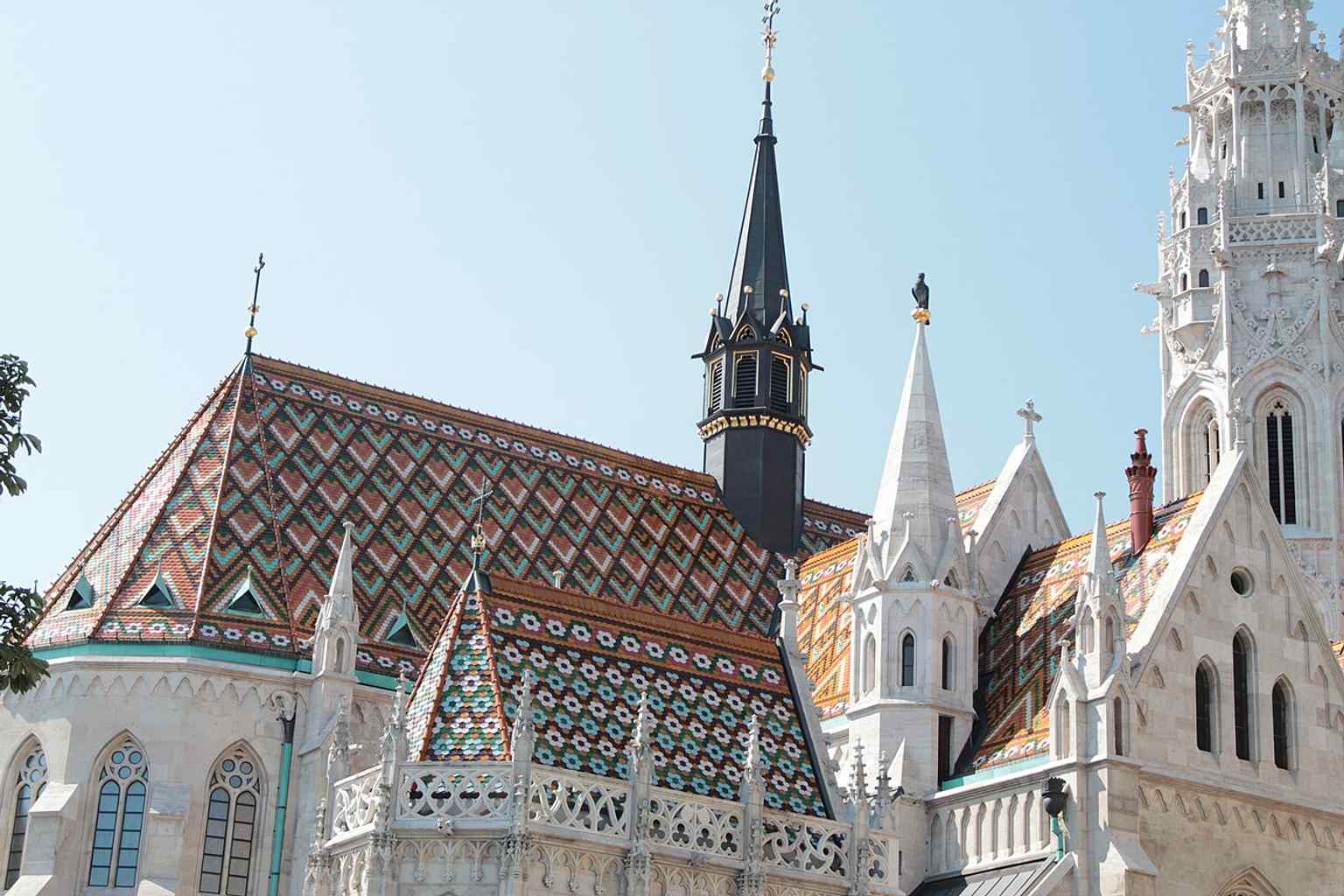 A close-up of the iconic diamond-pattern Zsolnay ceramic roof tiles, a controversial but striking addition by architect Frigyes Schulek.