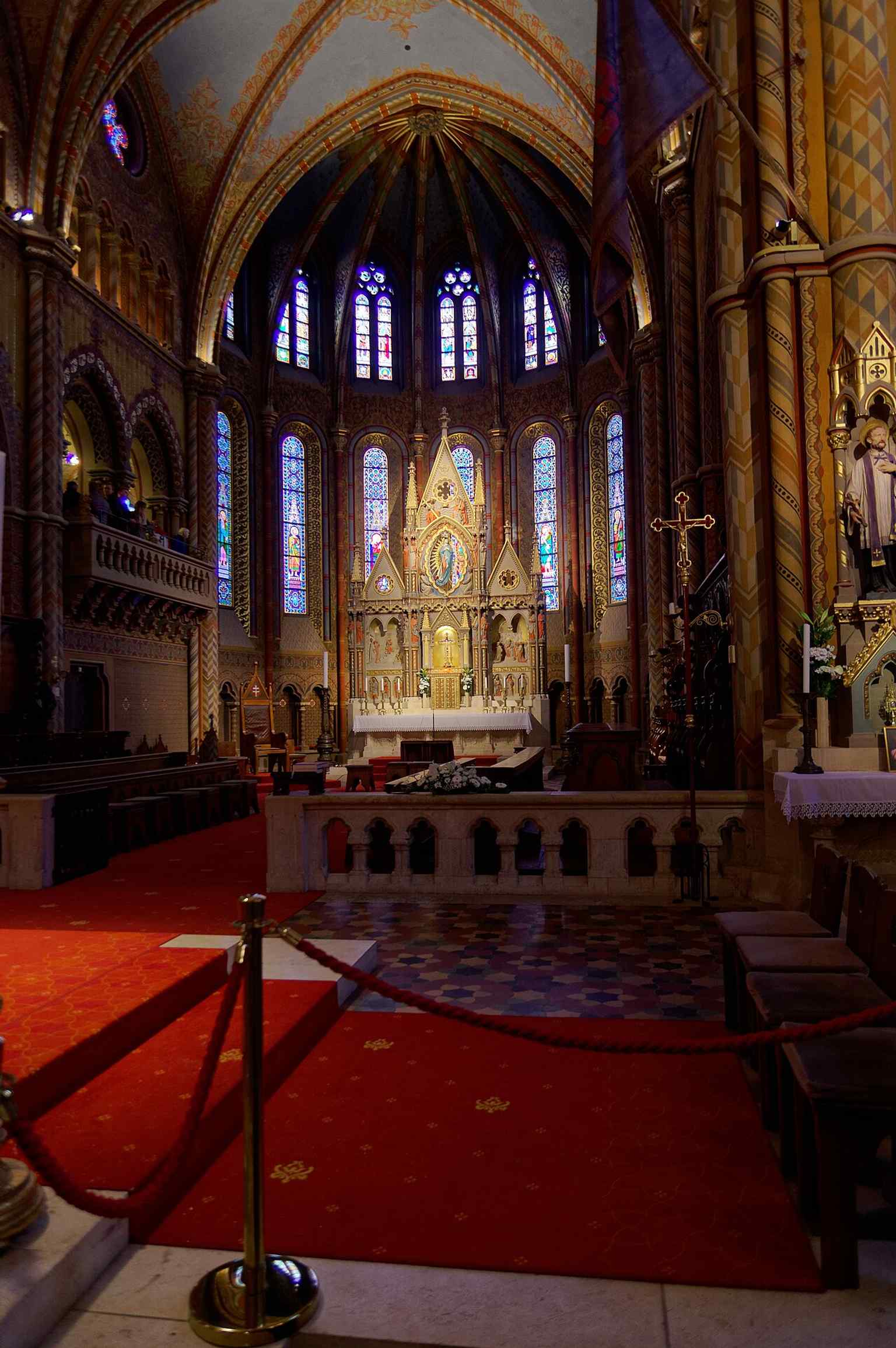 A wide interior view showcasing the extensive and vibrant Neo-Gothic wall paintings and frescoes by Bertalan Székely and Károly Lotz.