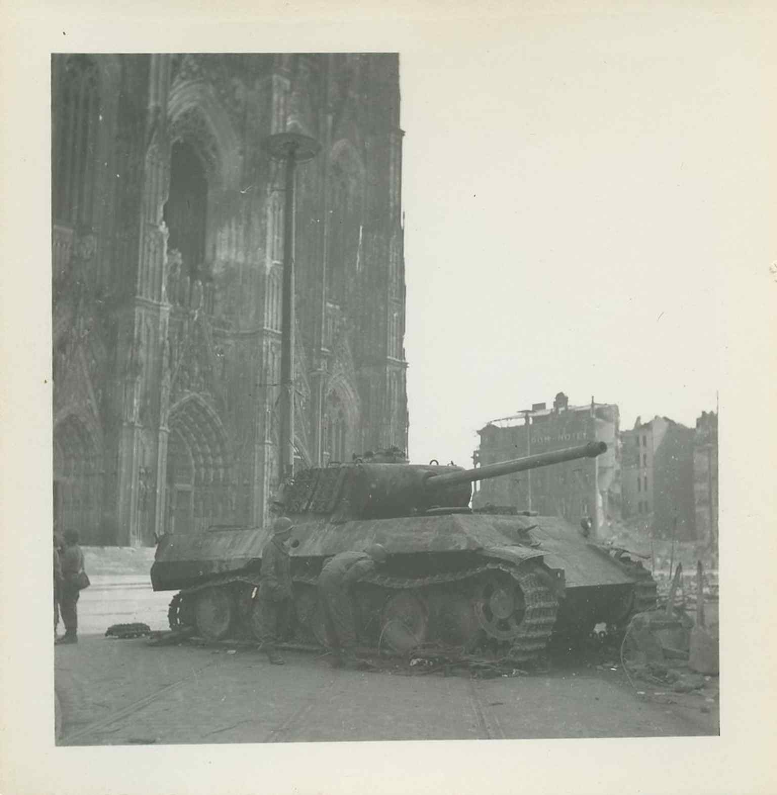 Dieses Foto aus dem Jahr 1945 zeigt den Kölner Dom, der inmitten der Trümmer der stark zerbombten Stadt weitgehend intakt blieb, was dazu führte, dass er nach dem Zweiten Weltkrieg als 'Wunder' und Symbol der Widerstandsfähigkeit wahrgenommen wurde.