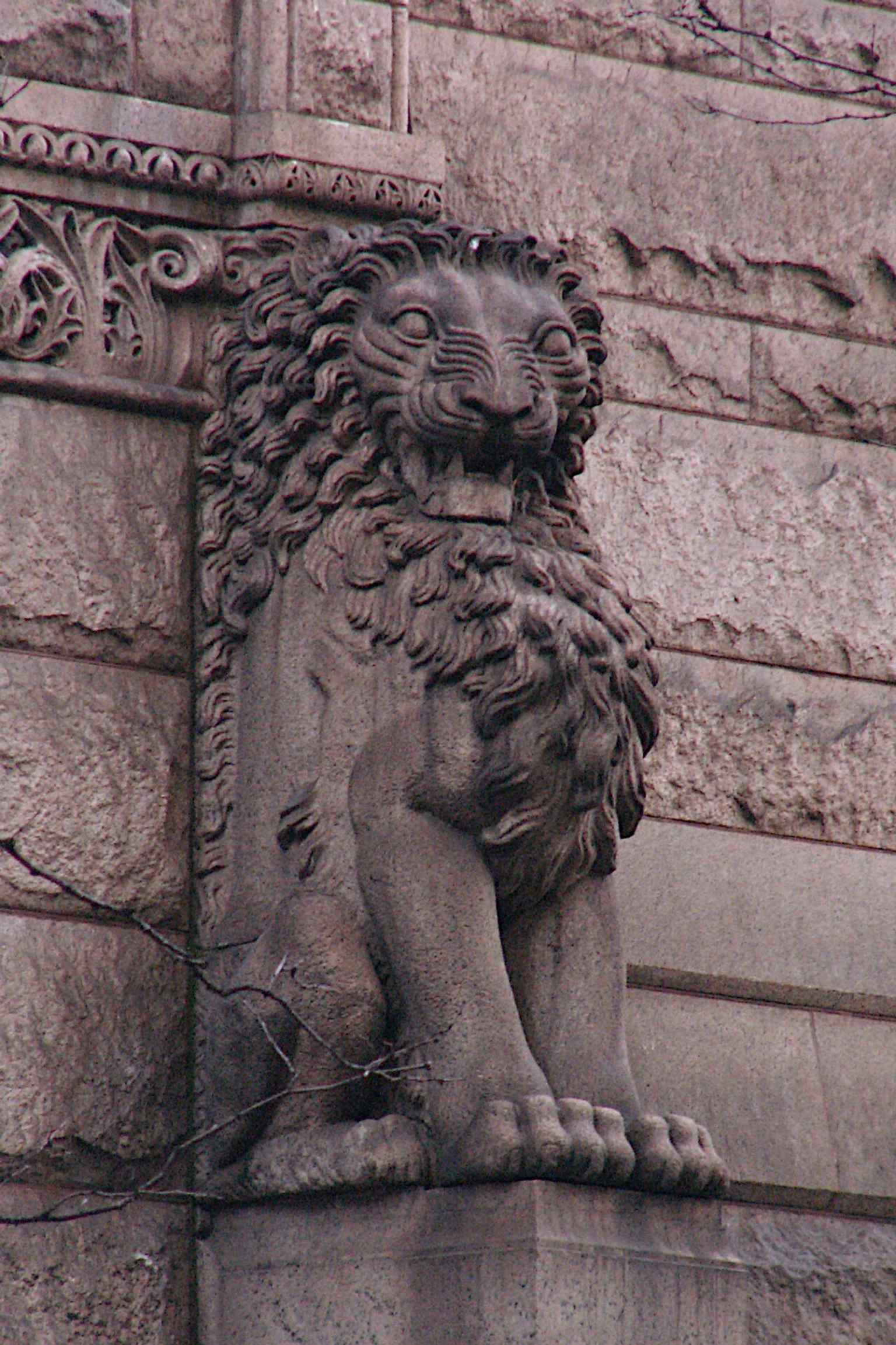 A detailed view of a lion decoration, one of the many rusticated granite architectural elements that give the courthouse its heavy, stable, and dignified appearance.